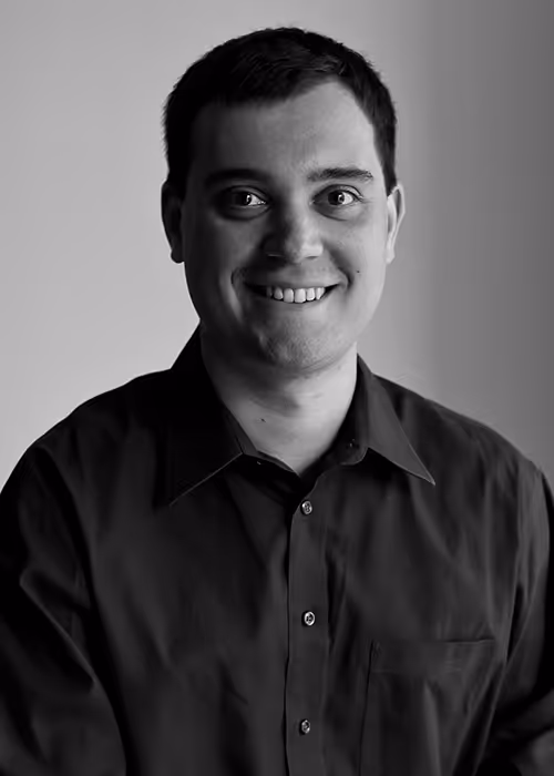 Portrait of James Darling, jazz piano faculty member, wearing a dark button-up shirt.