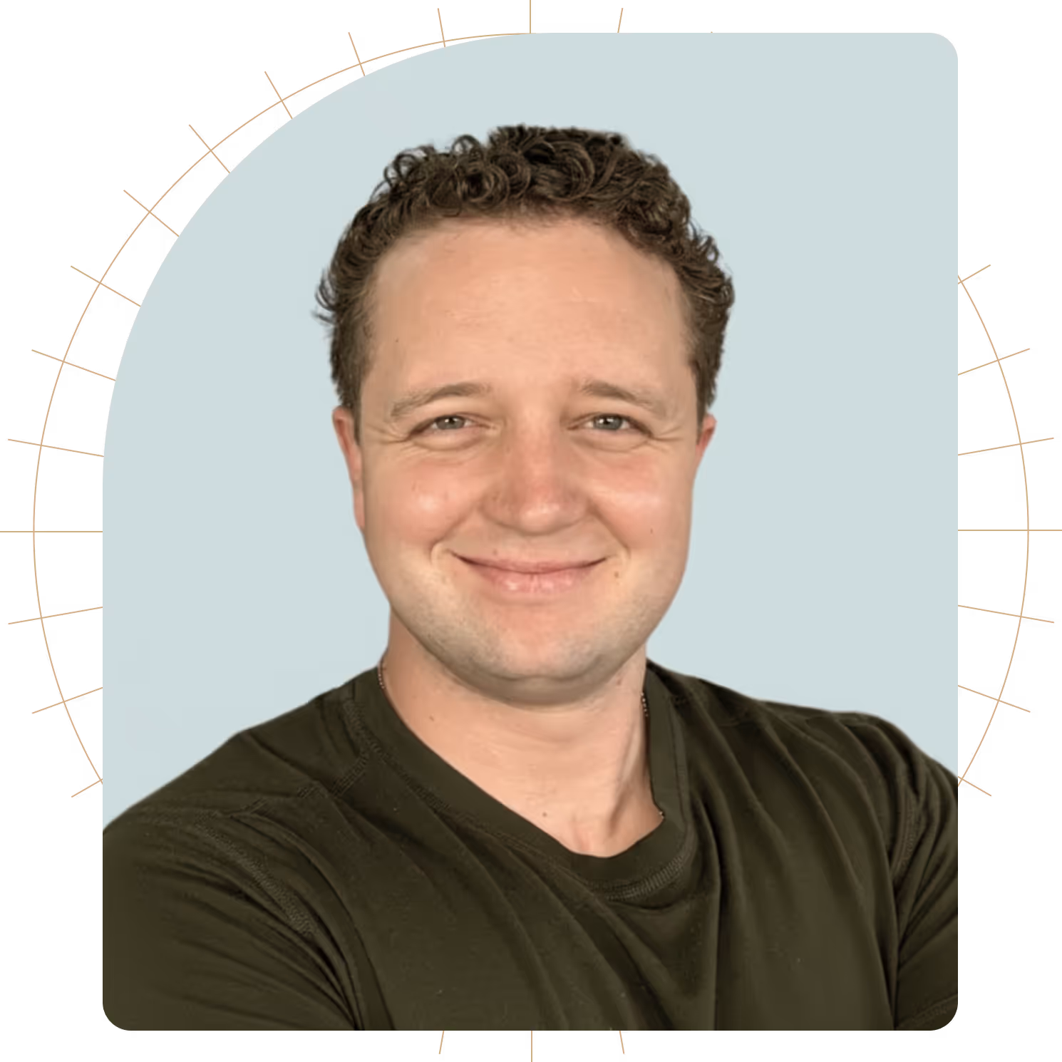 Smiling man with curly hair wearing a dark green shirt against a light blue background with radial lines.