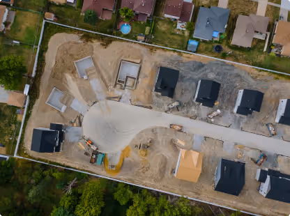 Aerial view of a residential construction site with partially built houses and cleared lots.