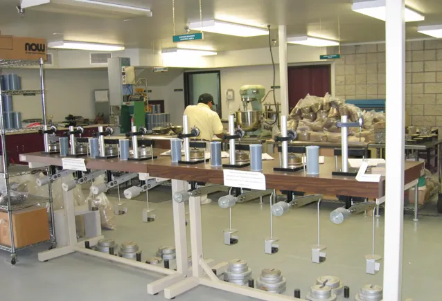 Laboratory room with a man working and a series of suspended weights for experiments.