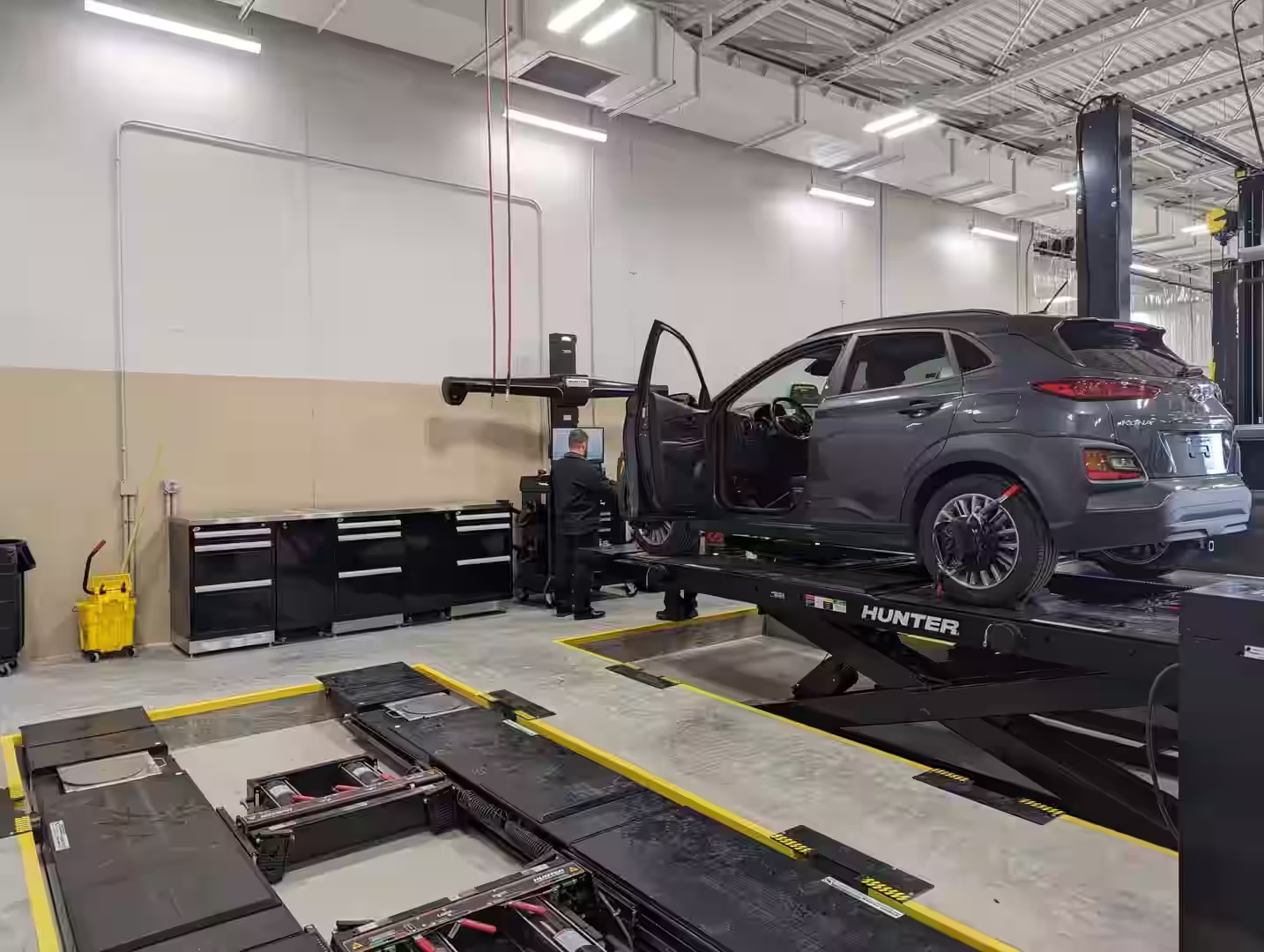 A team of professional installers setting up a new automotive alignment system - Wade shop maintenance A team of professional installers setting up a new automotive alignment system - Wade shop maintenance