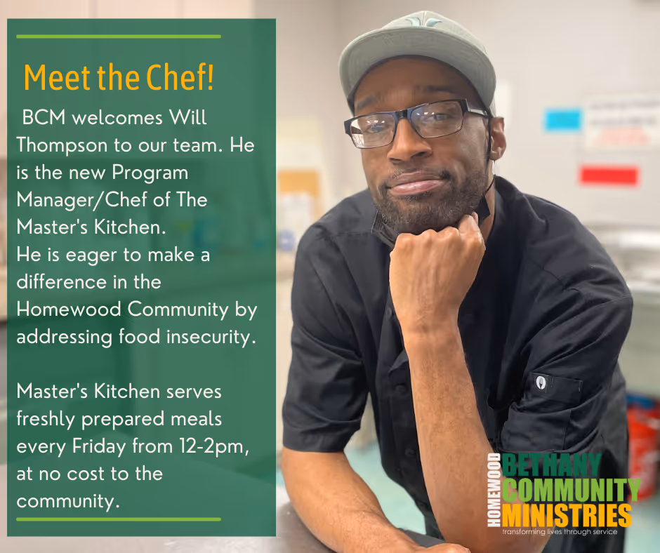 Will Thompson leans over the counter in the kitchen and smiles at the camera