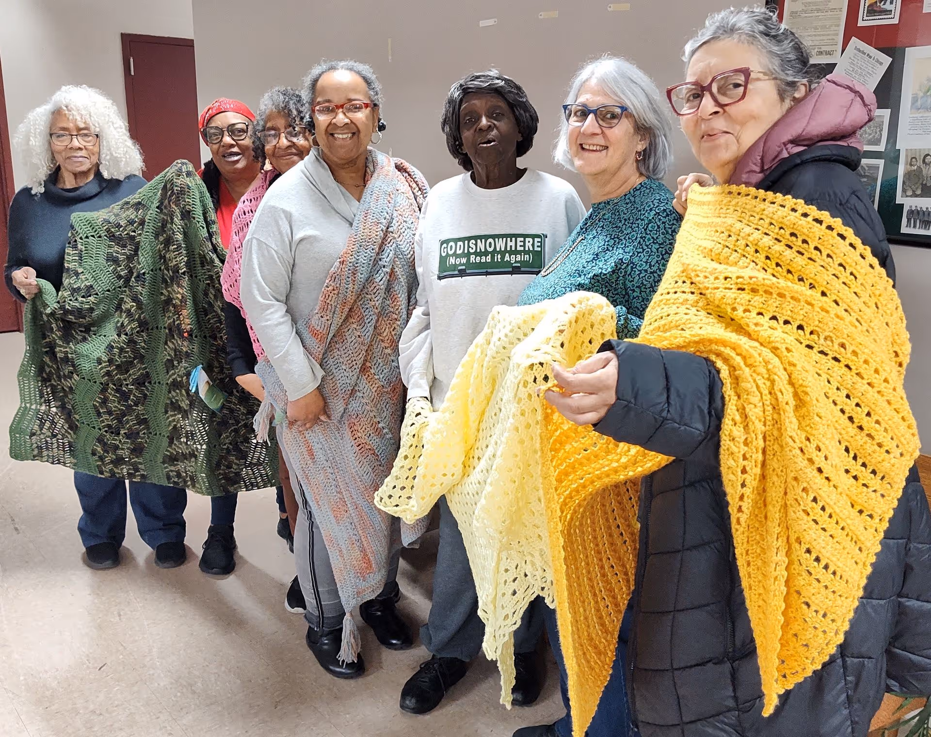 A group of volunteer makers pose with the afghans they are preparing to donate.