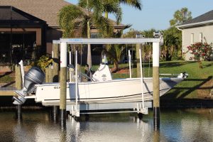 A 10,000 lb. boat lift with a white boat and palm trees in the background.