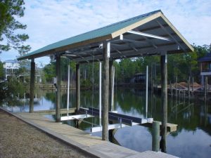 An empty boathoust lift built off of the seawall features a cradle boat lift and a green roof.