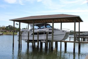 A boathouse holds a large double-hull vessel.