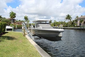 A v-hull boat on a boat elevator built off the seawall.