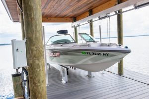 A small v-hull boat inside of a wood boathouse lift.