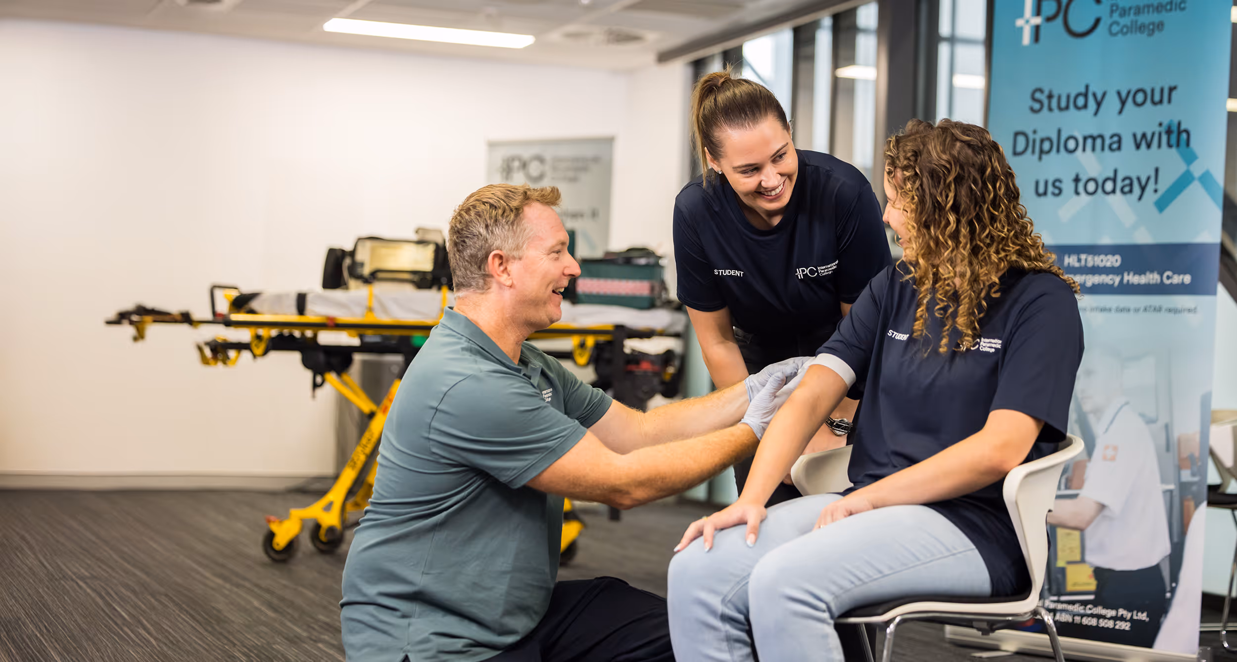 Hands-on paramedic training session at International Paramedic College with students learning practical skills