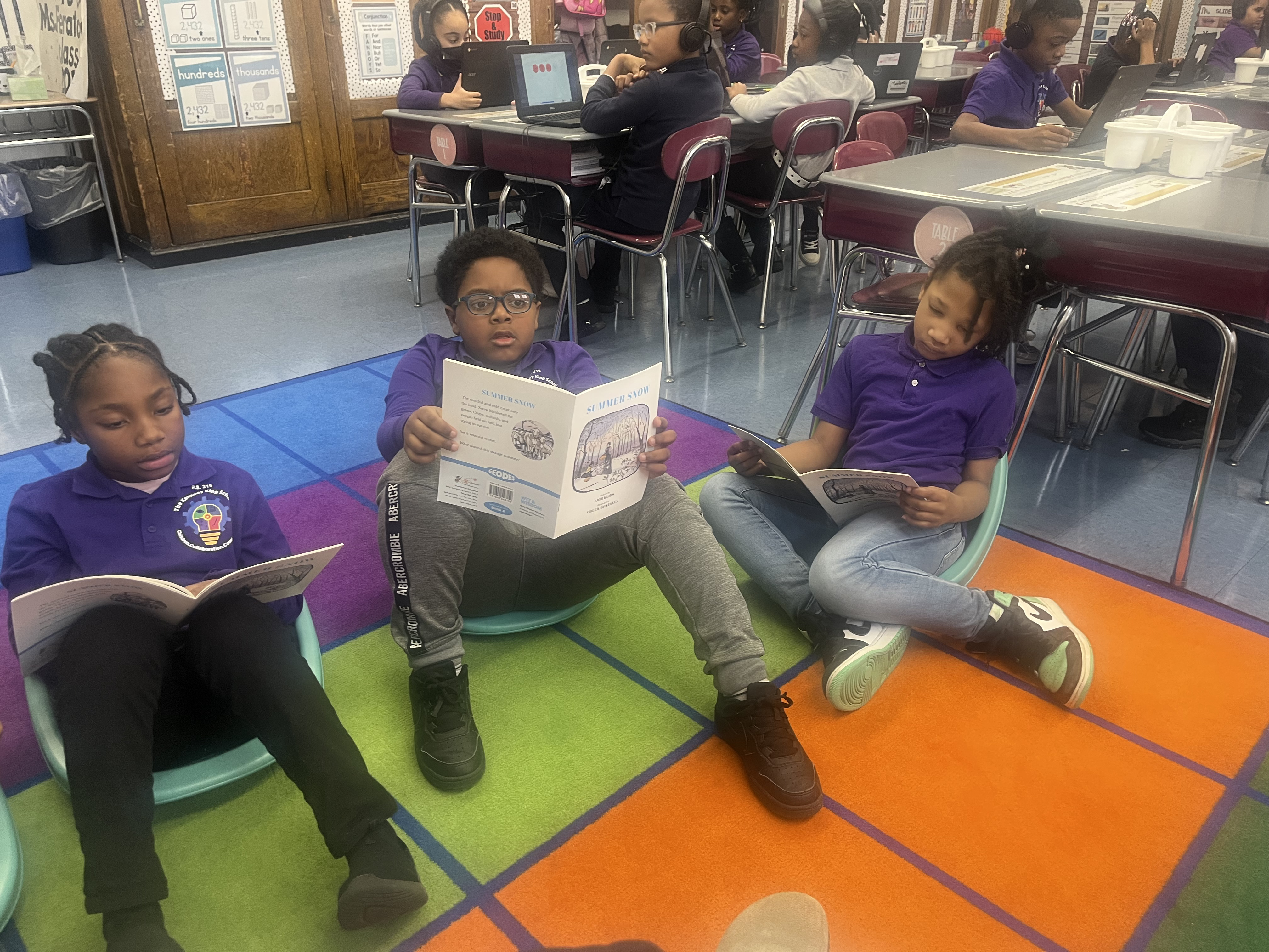 Five children standing on a polished gym floor 