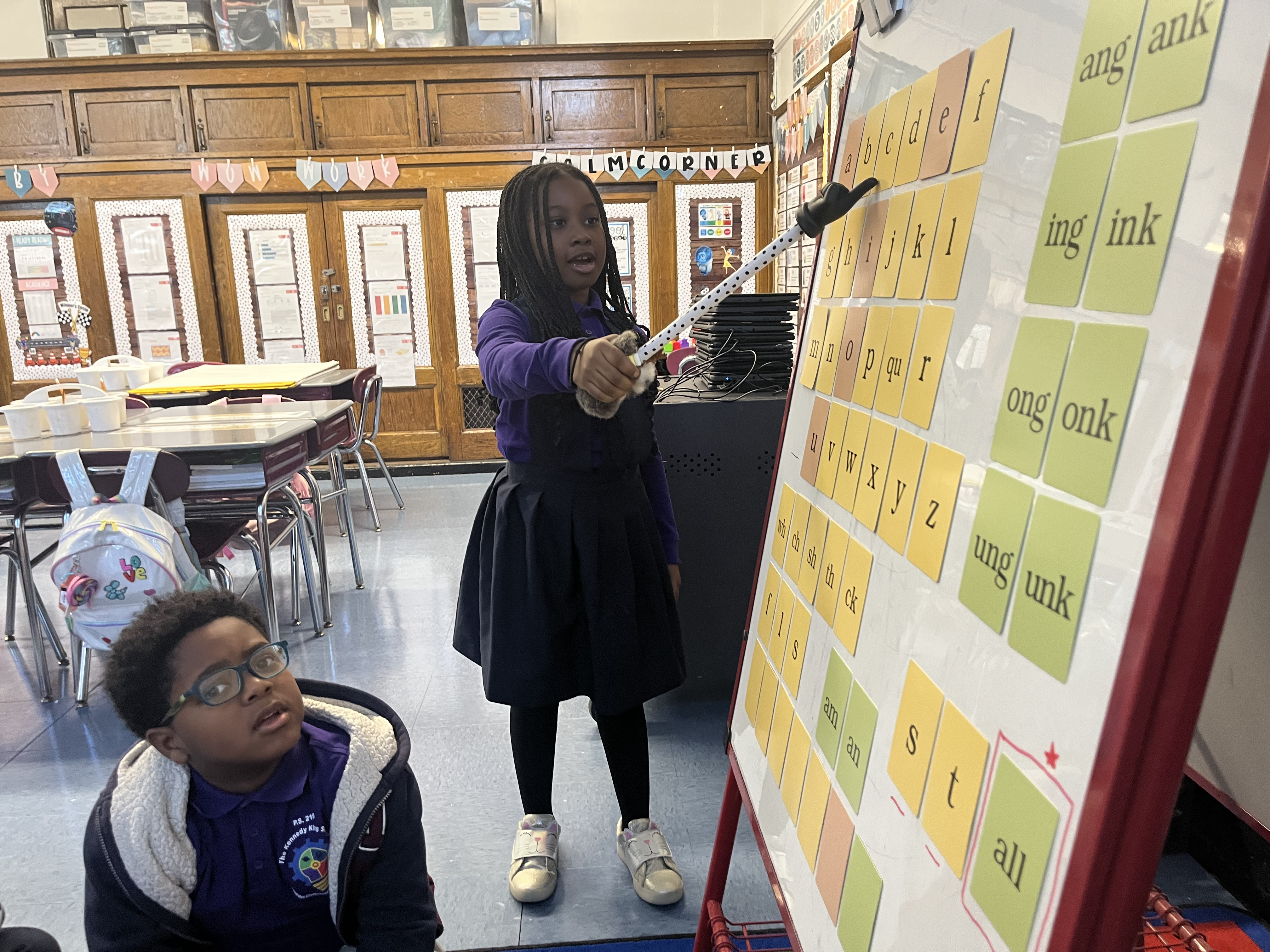 Five children standing on a polished gym floor 