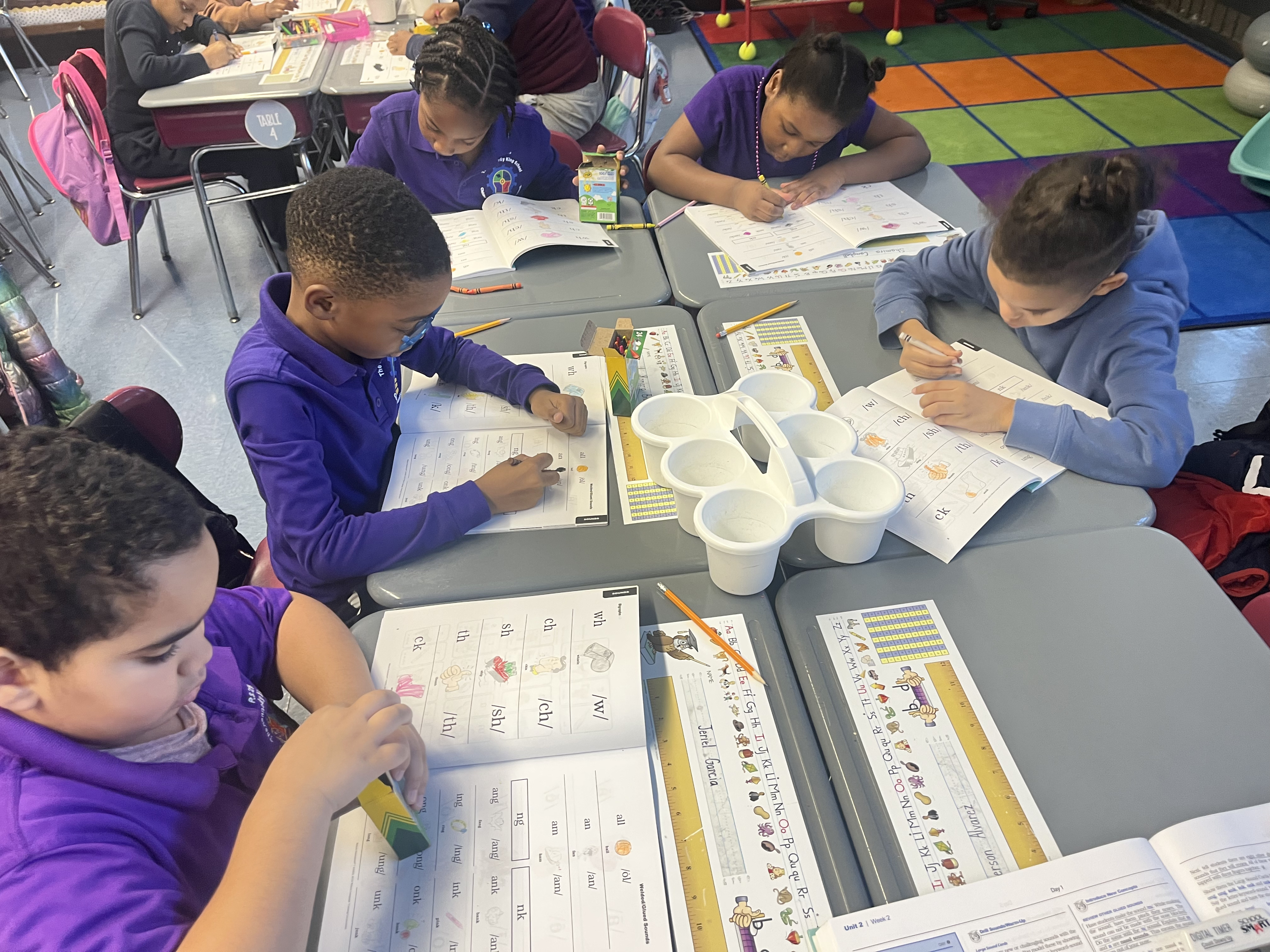 Five children standing on a polished gym floor 