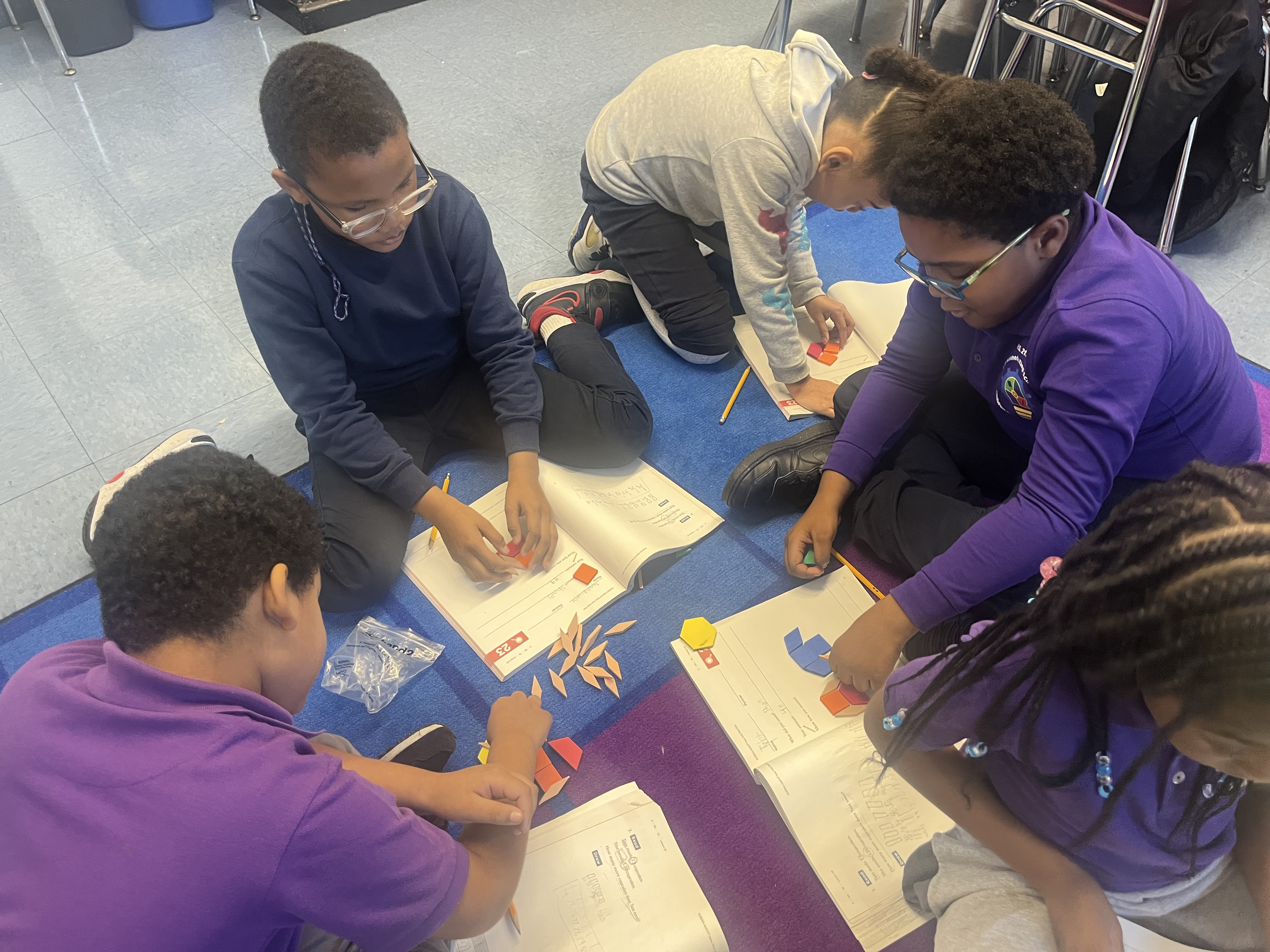 Five children standing on a polished gym floor 