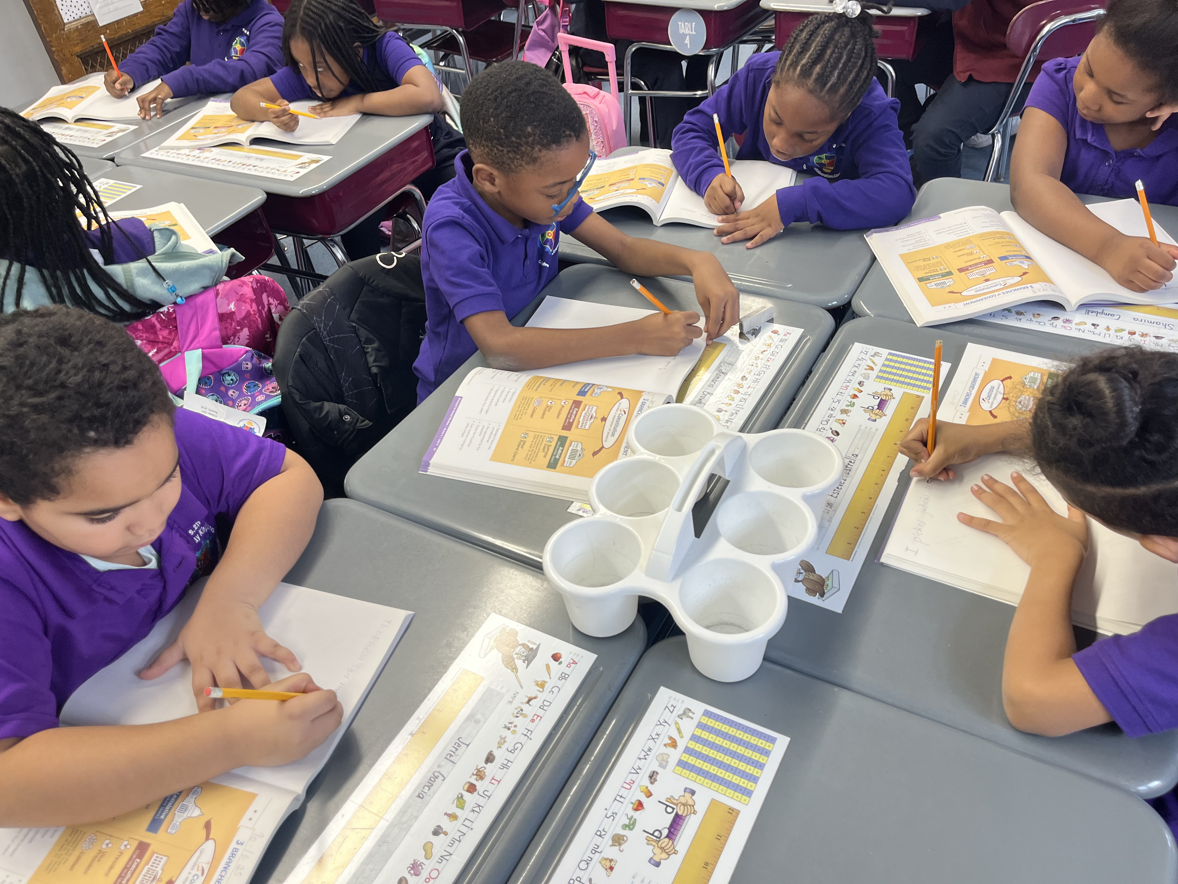 Five children standing on a polished gym floor 