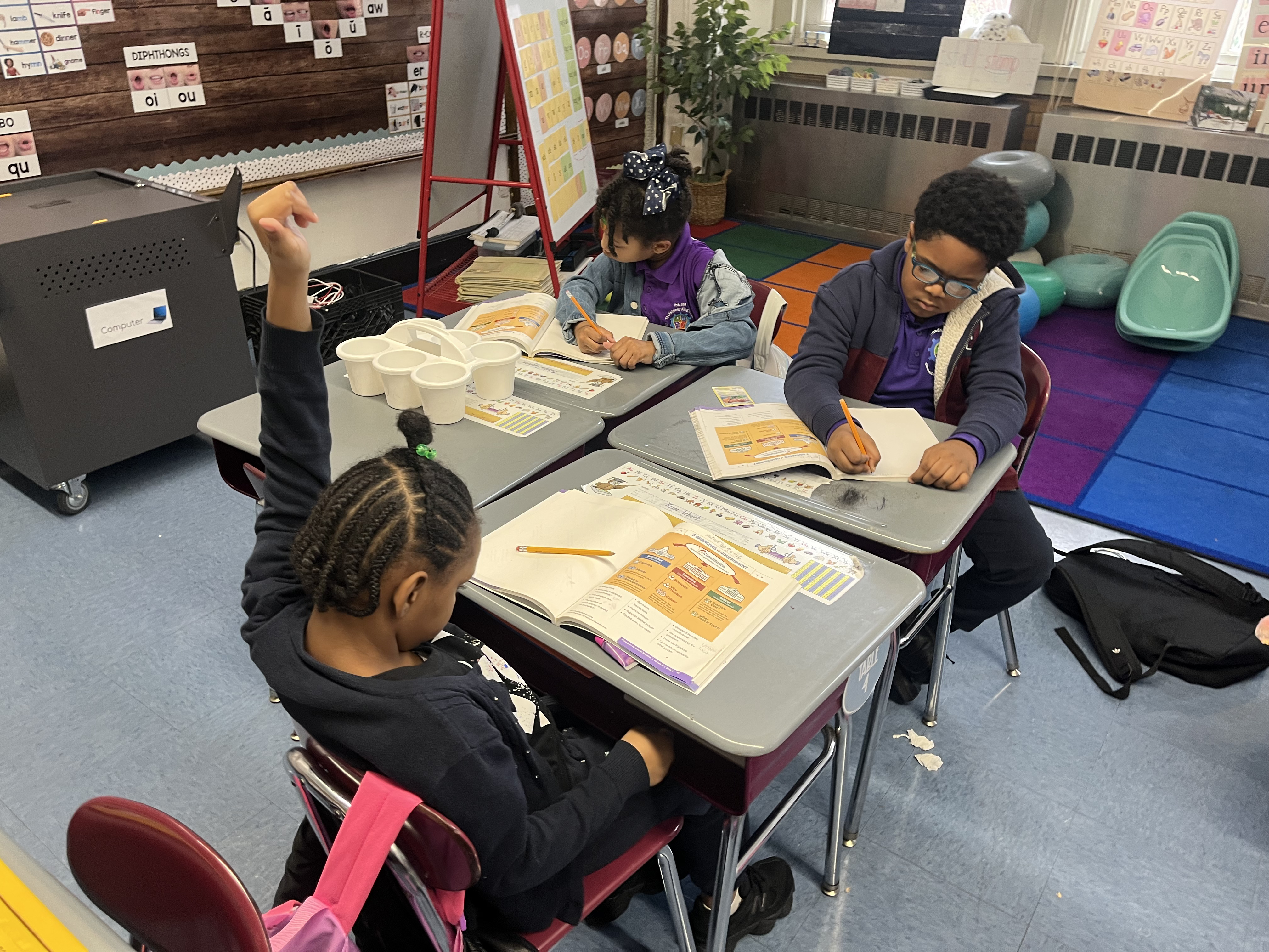 Five children standing on a polished gym floor 