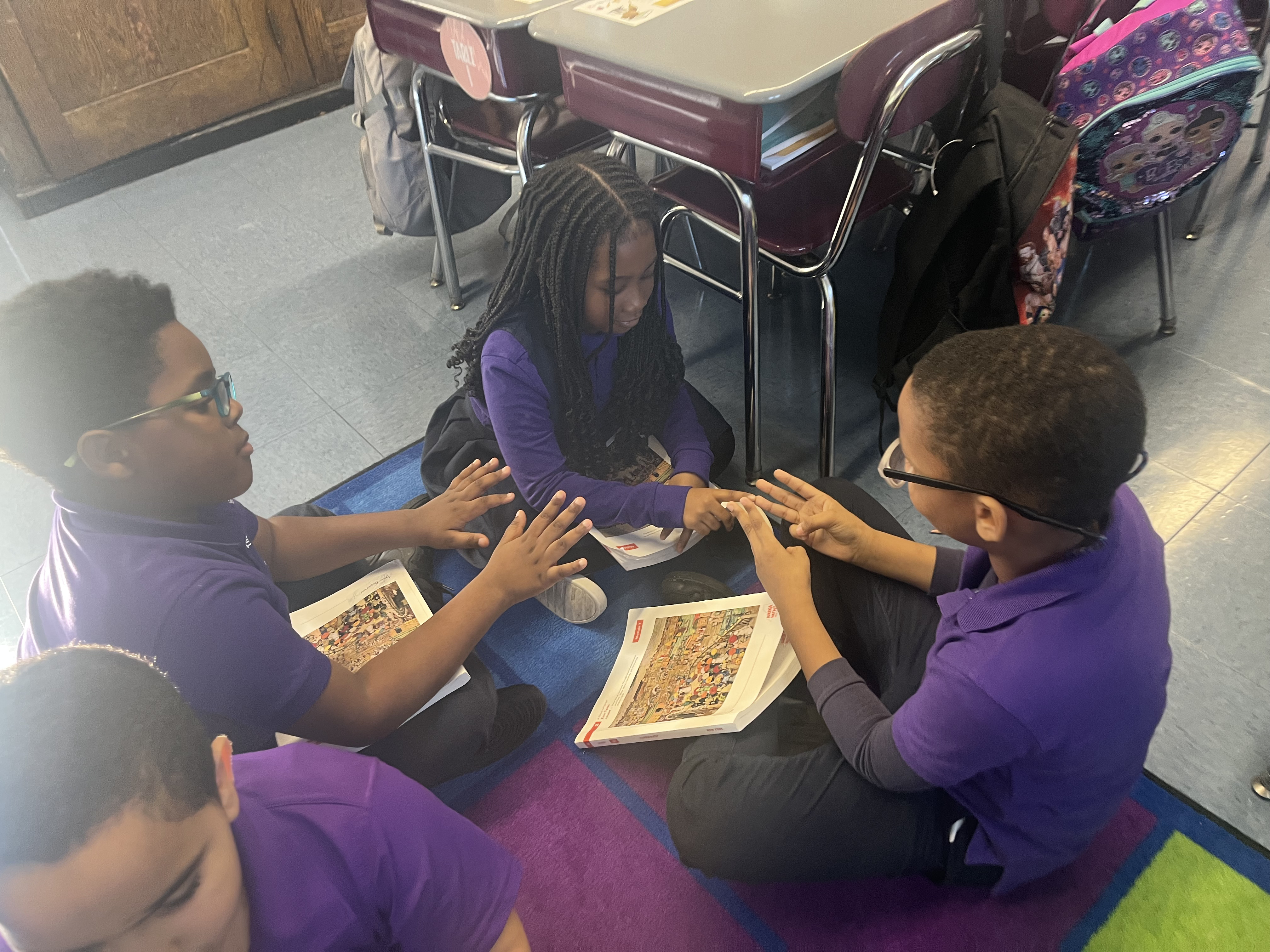 Five children standing on a polished gym floor 