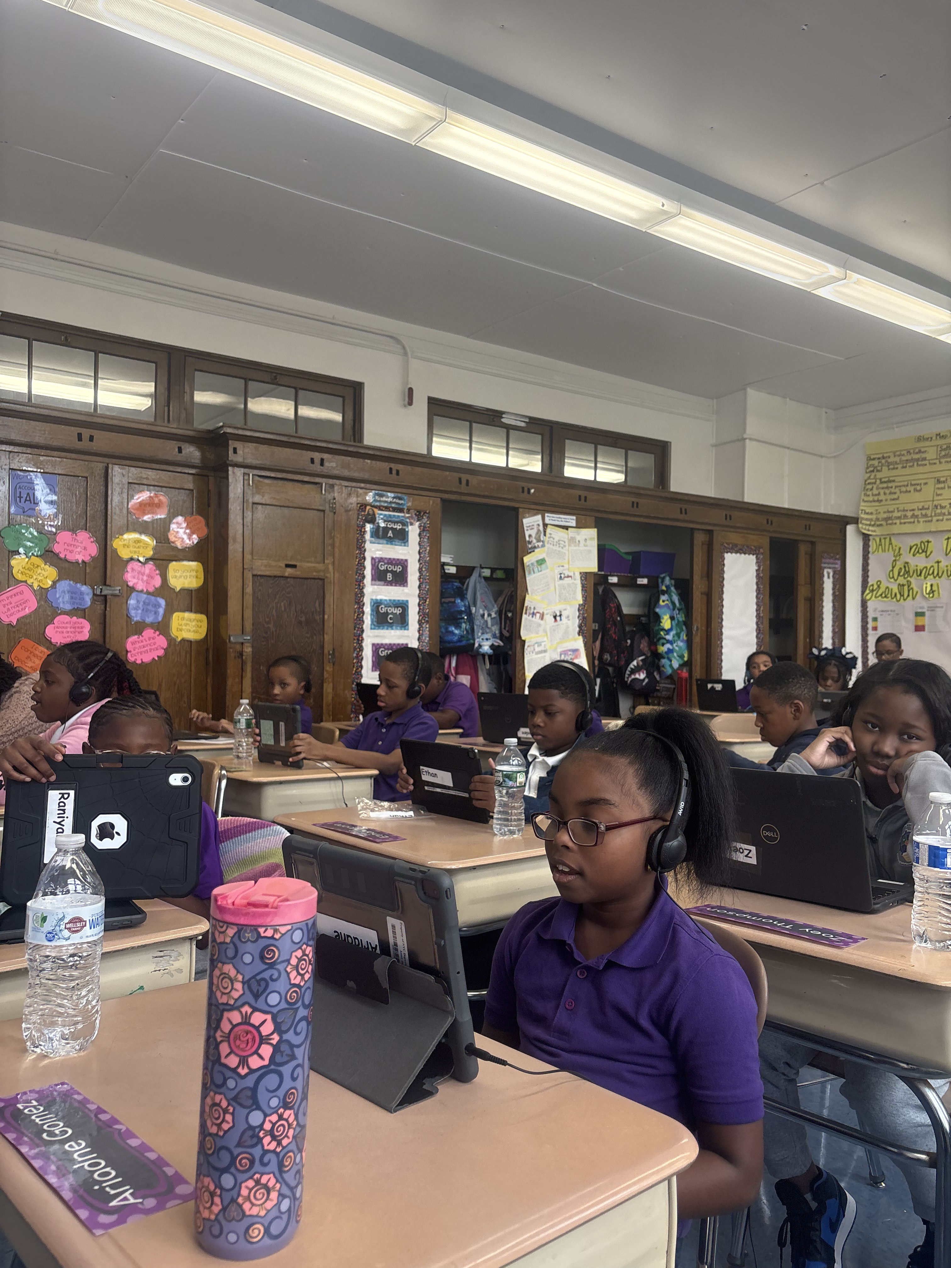 Five children standing on a polished gym floor 