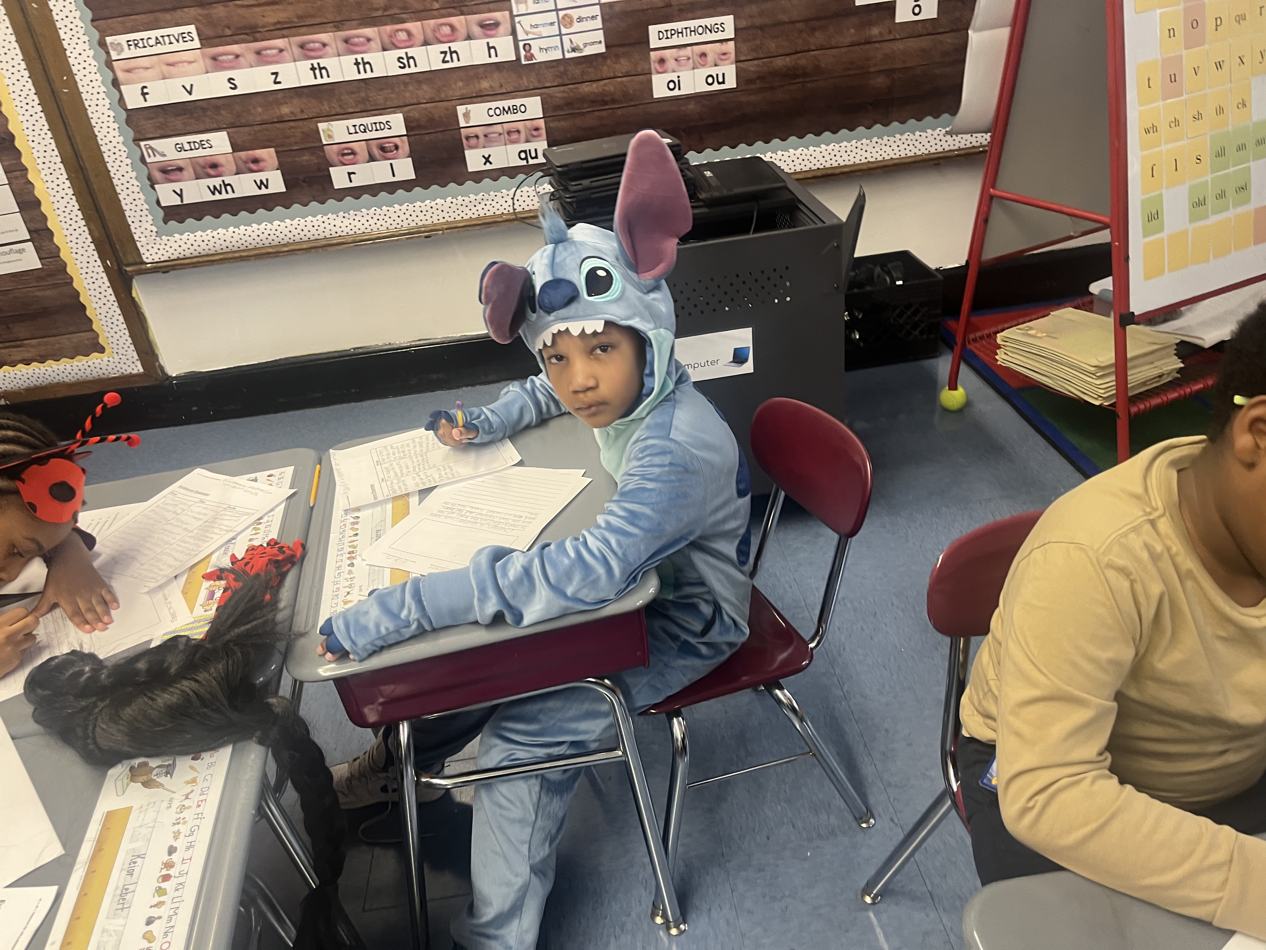 Five children standing on a polished gym floor 