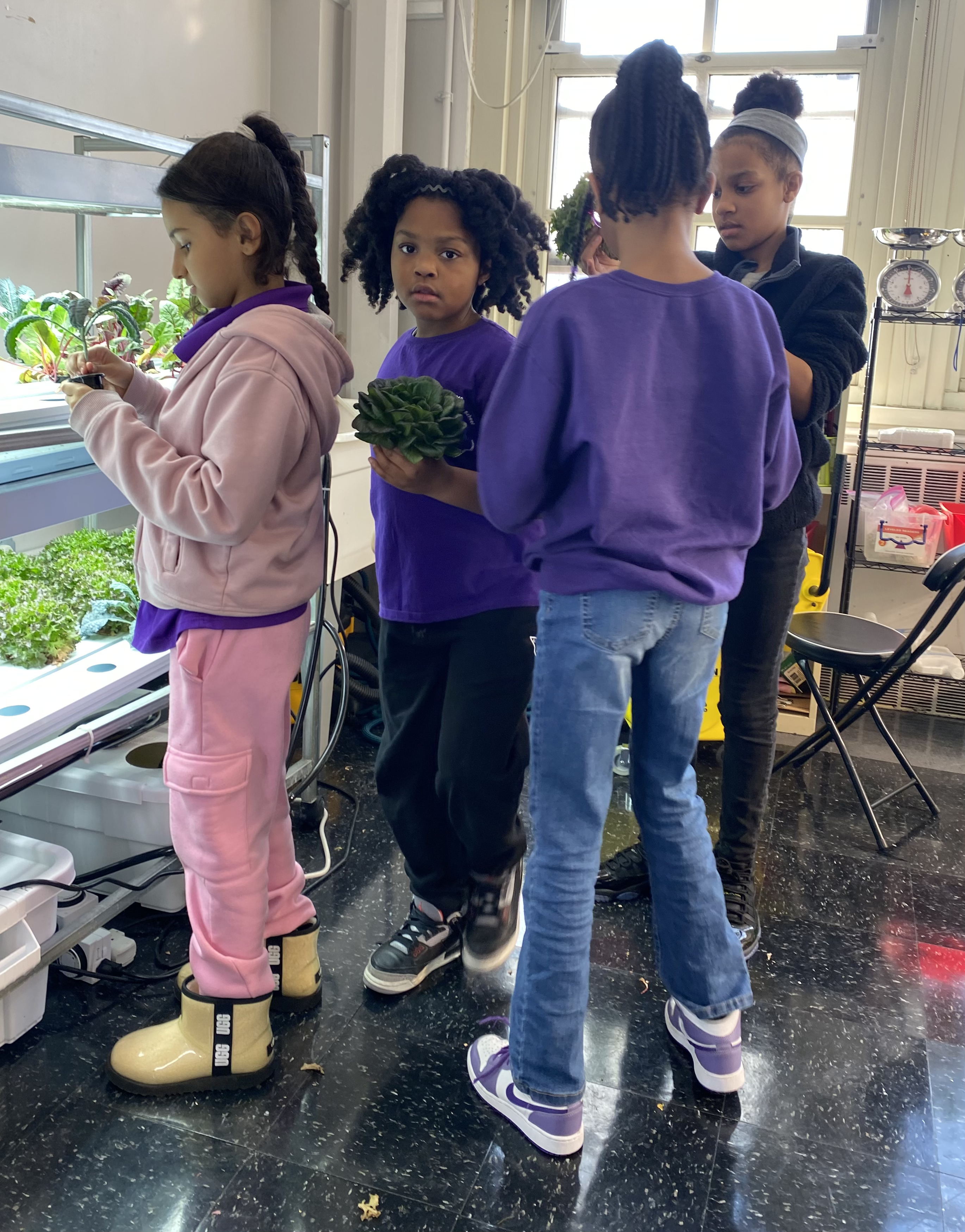 Five children standing on a polished gym floor 