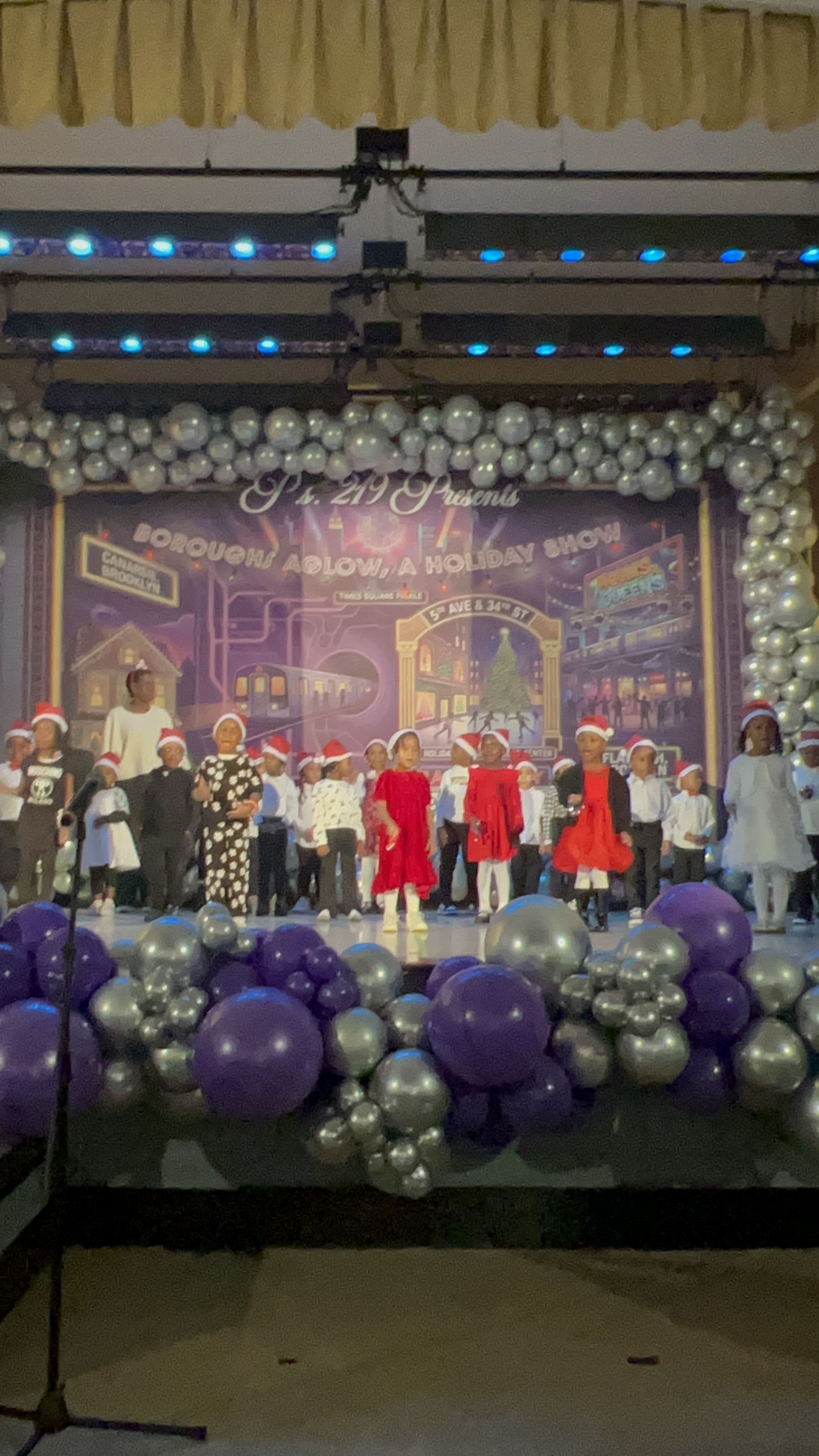 Five children standing on a polished gym floor 