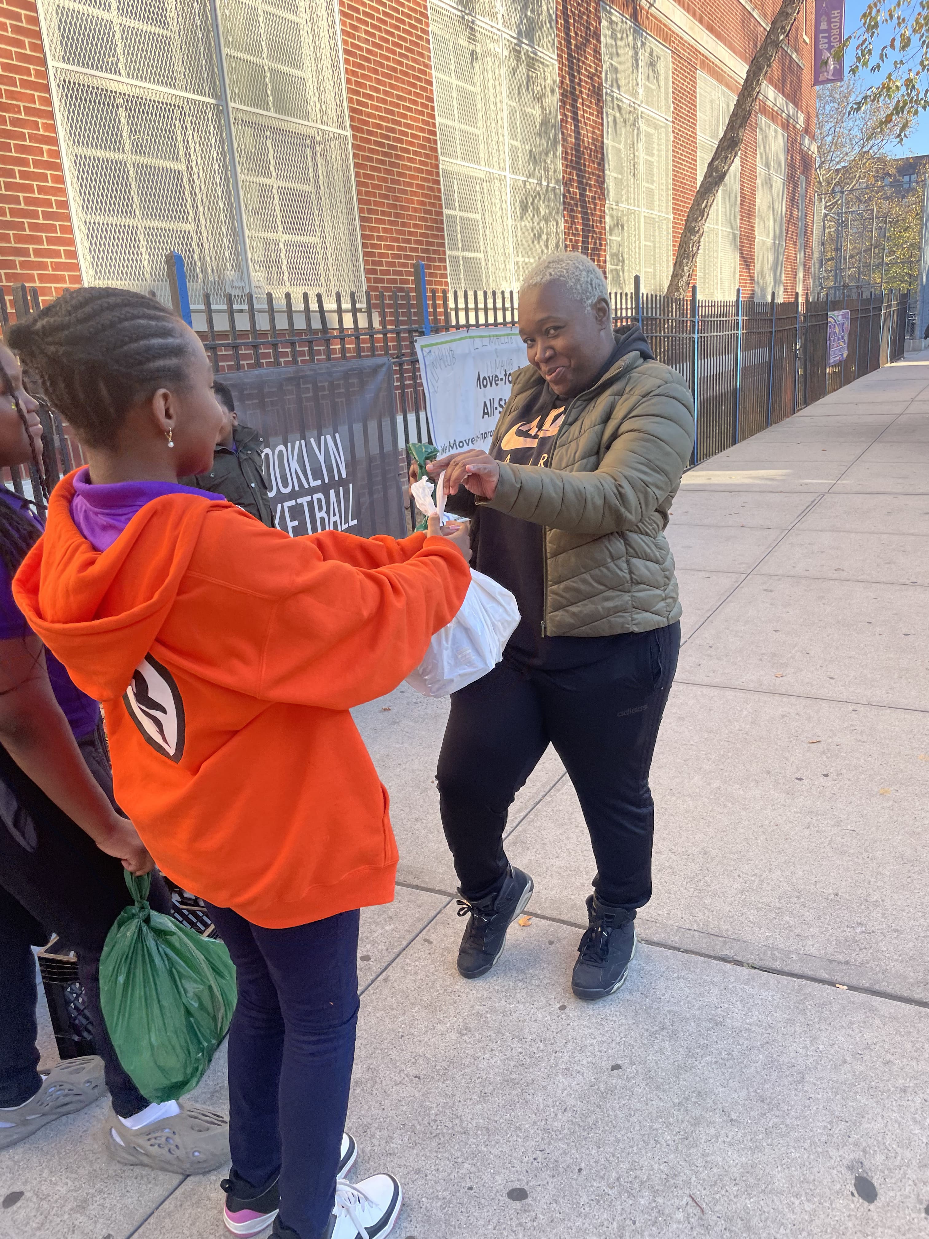 Five children standing on a polished gym floor 