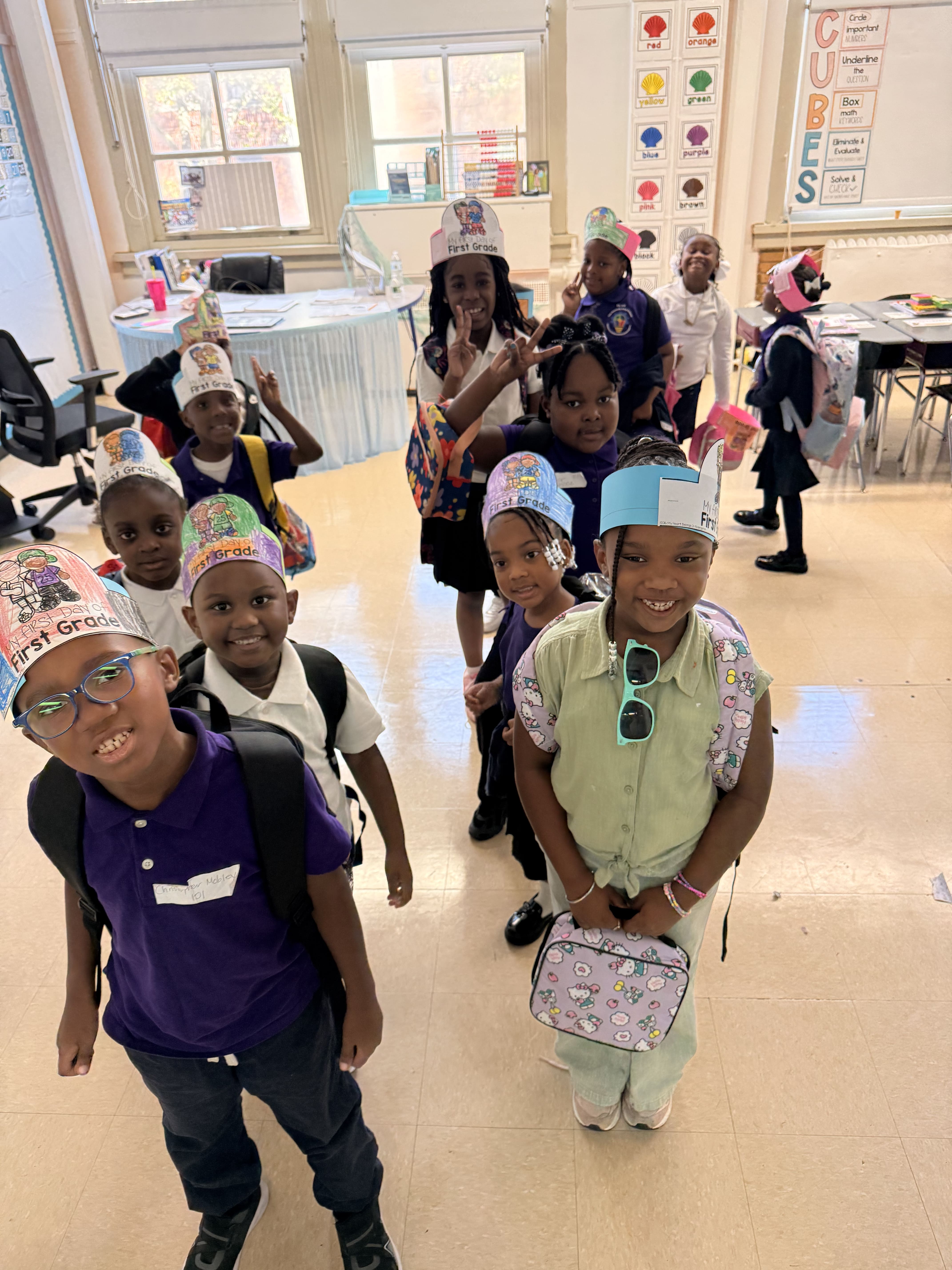 Five children standing on a polished gym floor 