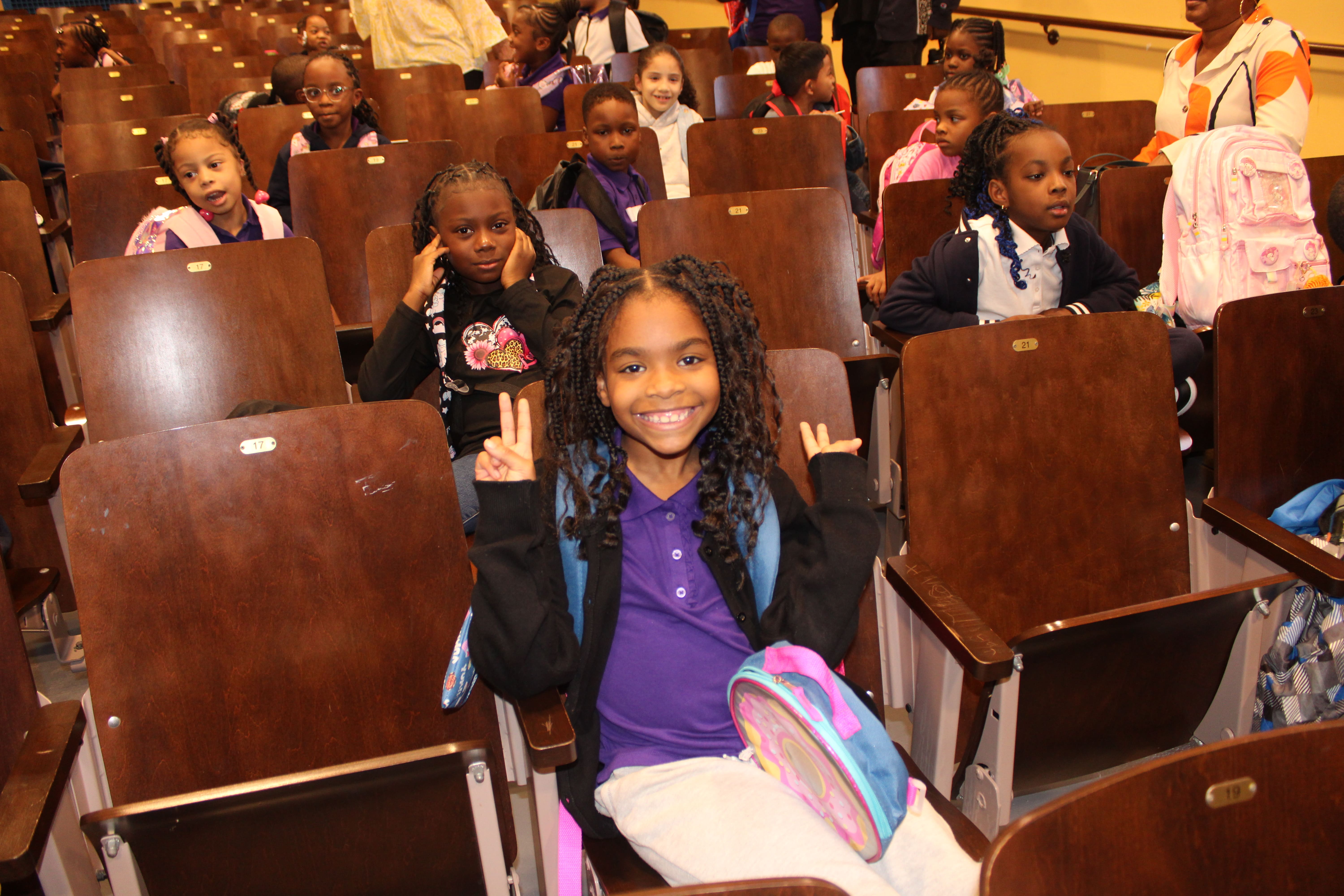 Five children standing on a polished gym floor 