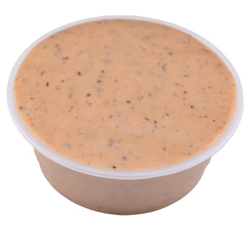 Small plastic container filled with creamy, speckled beige sauce.