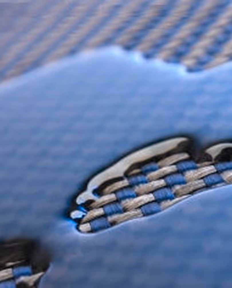 Primer plano de un tejido azul y gris con una superposición de superficie azul brillante.