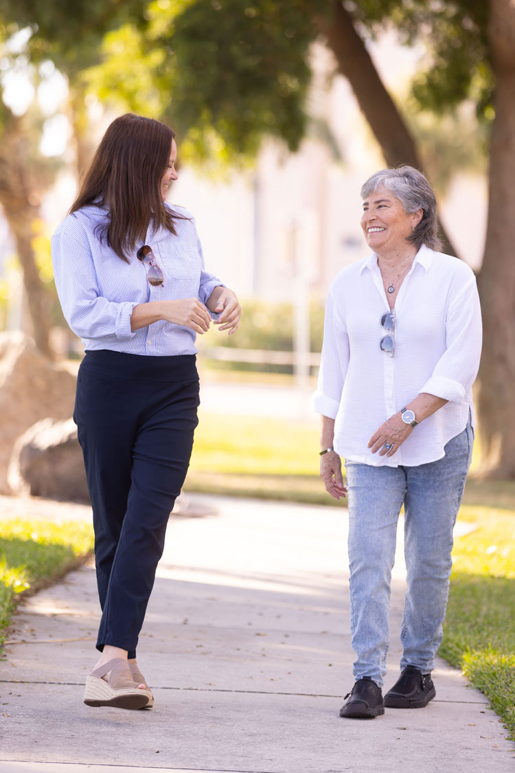 Geriatric care manager walking alongside an older adult during an outdoor conversation, offering guidance and companionship