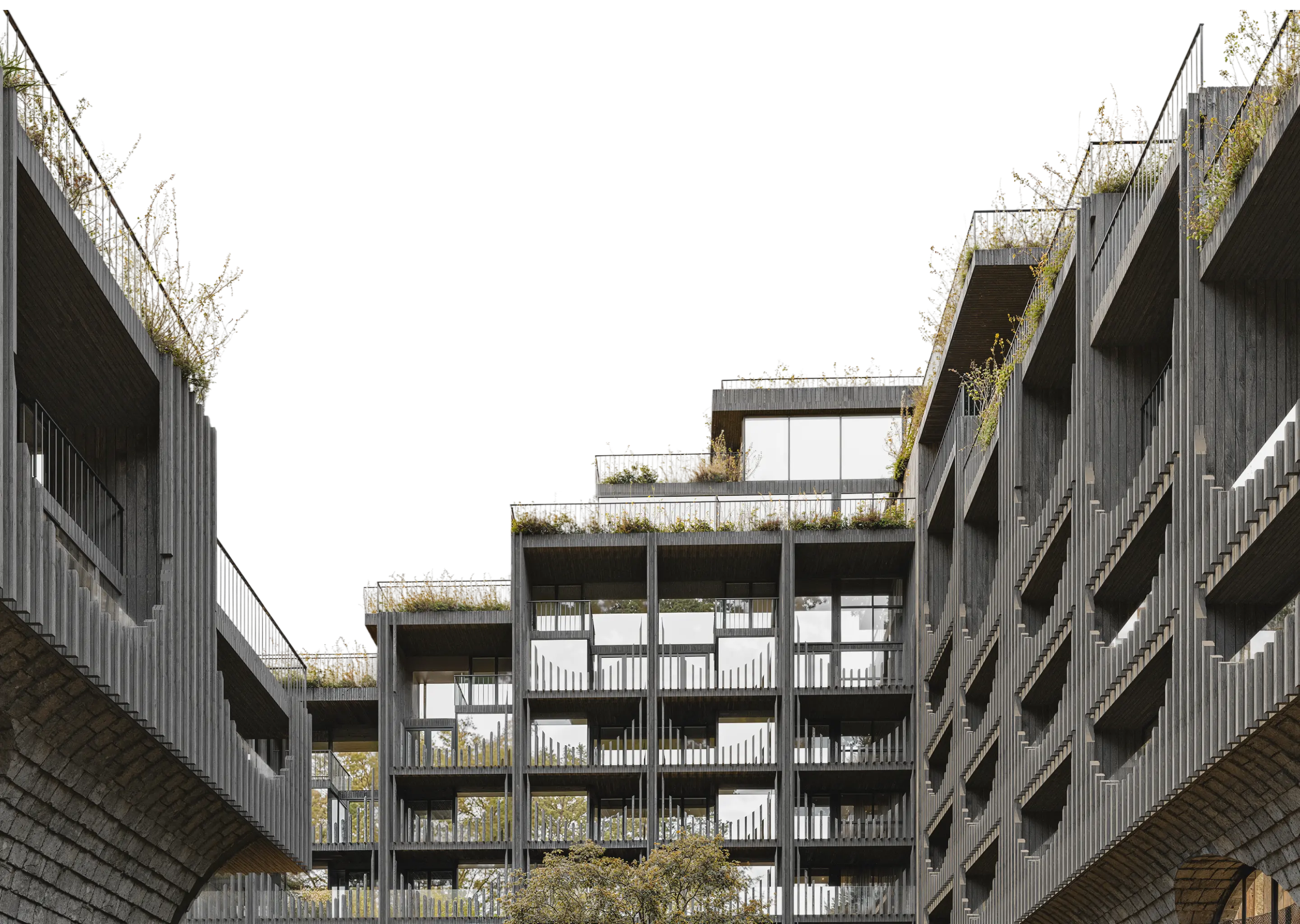 Сучасна багатоповерхова будівля з великими вікнами, балконами та зеленими насадженнями на дахах і поручнях.