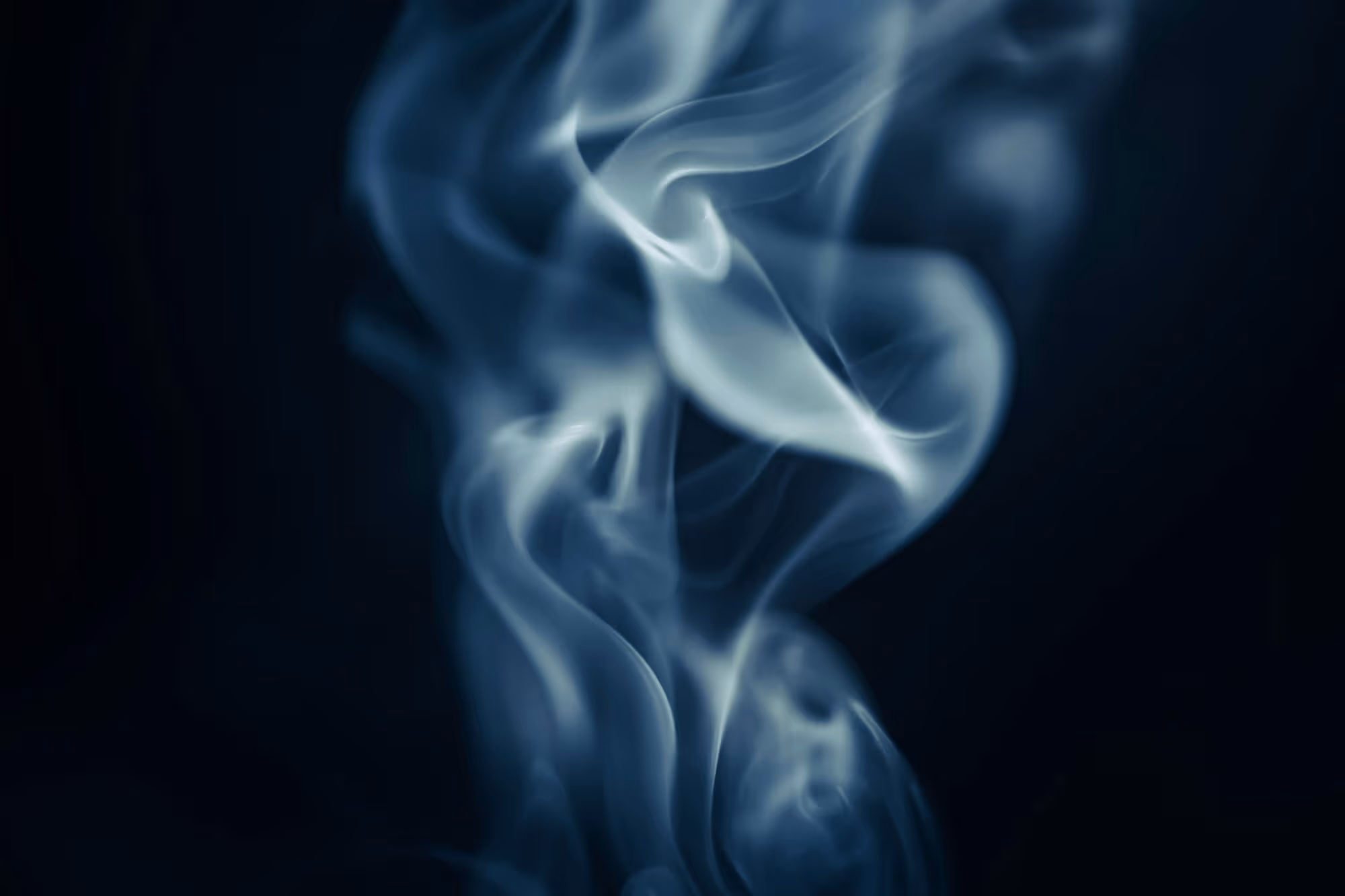 Wispy blue smoke swirling against a dark background.