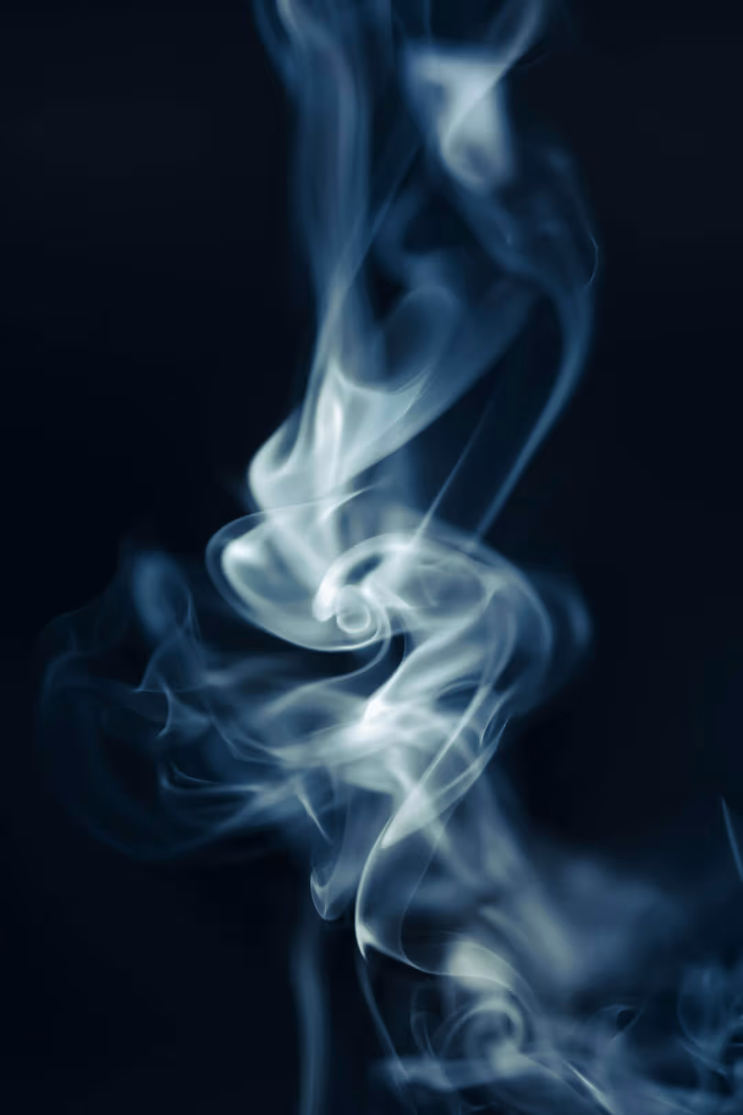 Close-up of white smoke swirling against a dark background.