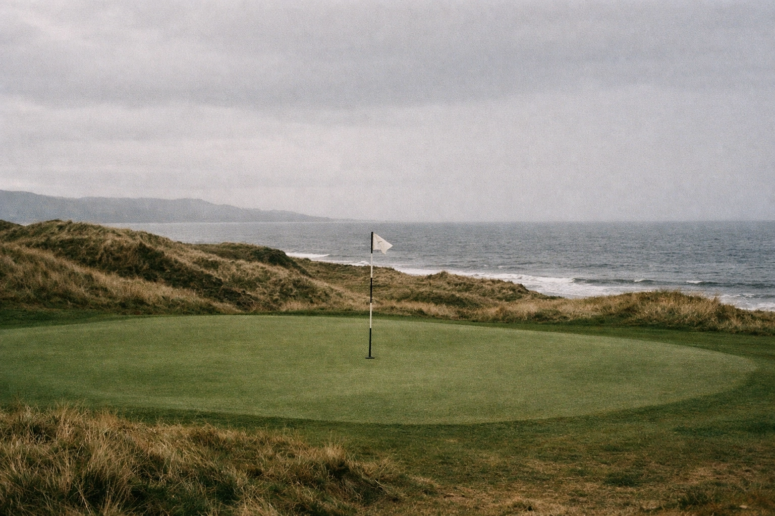 Scenic view of a rugged links golf green in Scotland, highlighting bucket-list golf travel destinations.