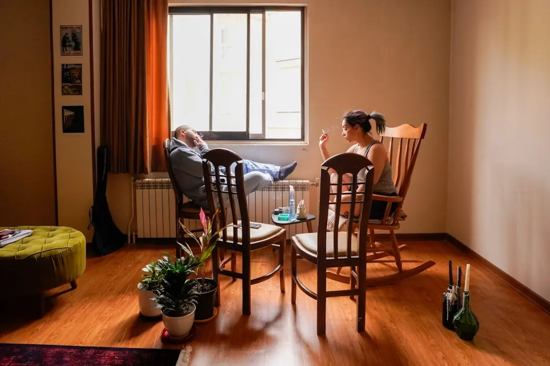 Man and woman smoking in living room.