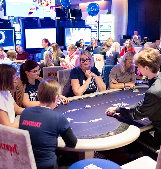 Participants playing poker at a live casino-style event, focused around a professional poker table.