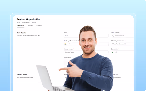 Smiling man in blue sweater pointing at a laptop screen with a Register Organization form displayed in the background.