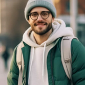Smiling young man wearing round glasses, a gray beanie, green jacket, white hoodie, and beige backpack outdoors.
