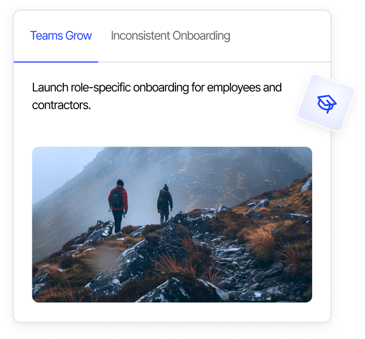 Two hikers walking on a rocky mountain trail with misty hills in the background.