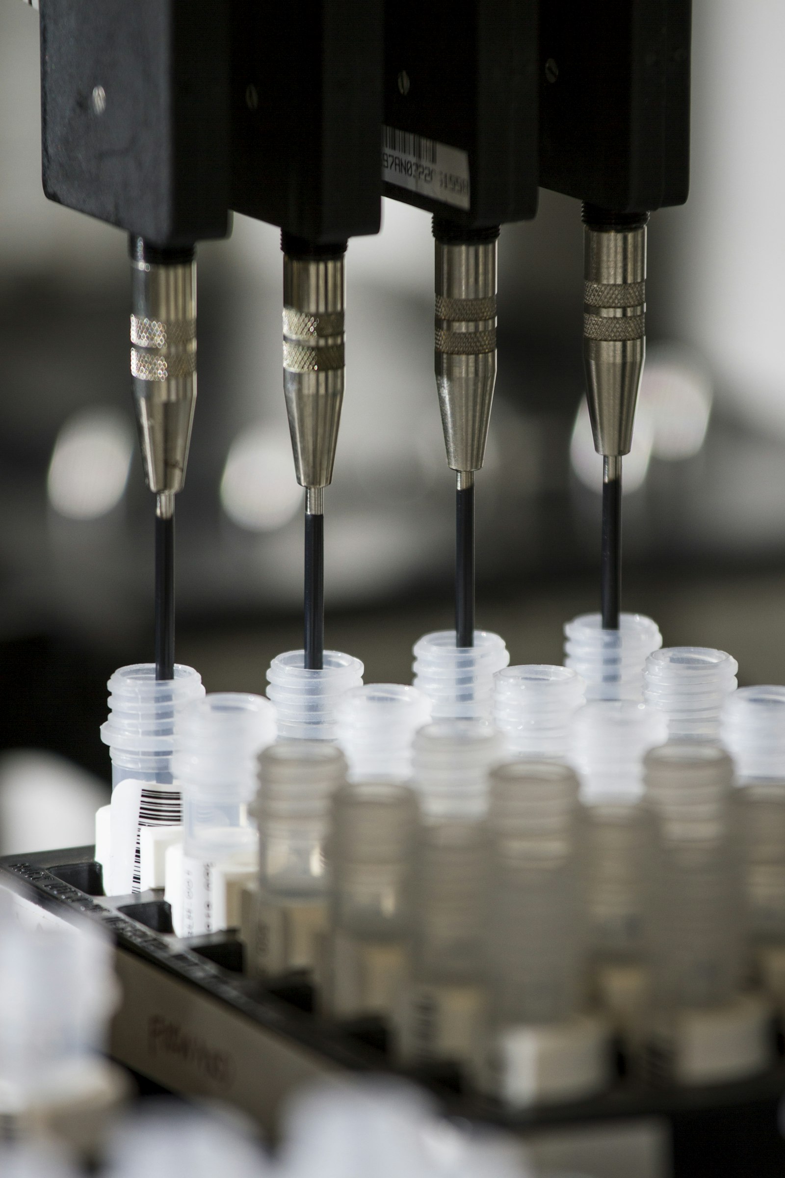 Automated pharmaceutical production line with regulated manufacturing equipment and laboratory containers