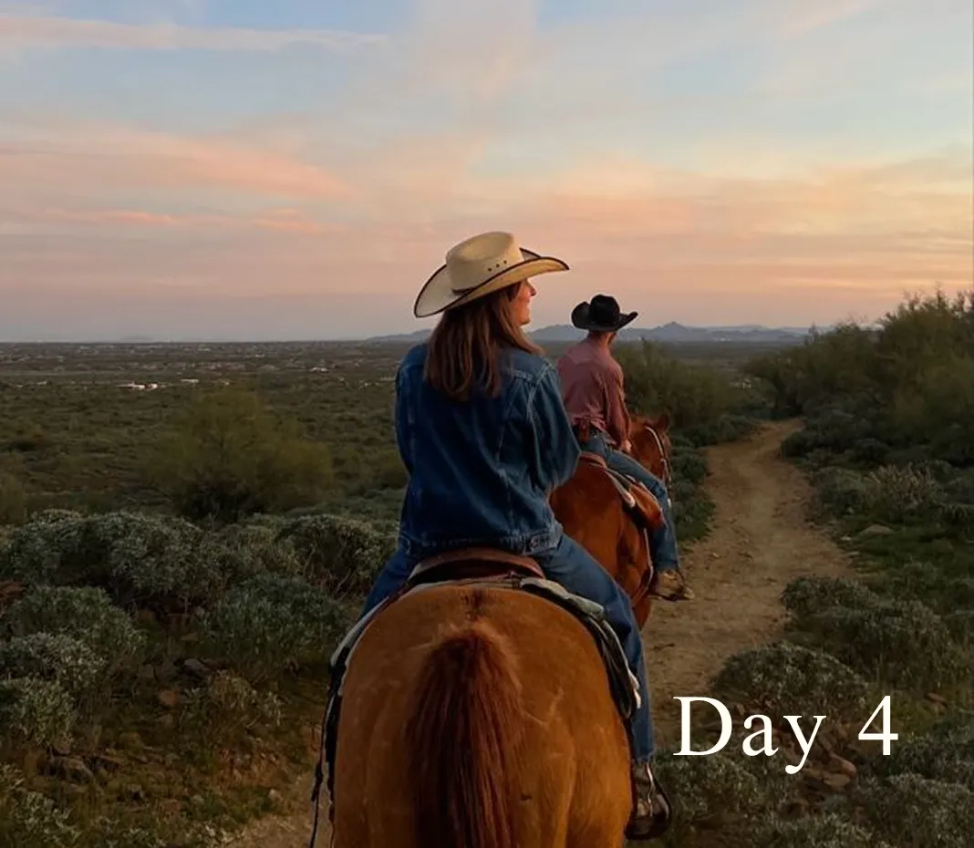 Two people wearing cowboy hats riding horses on a dirt trail through a desert landscape at sunset, with 'Day 4' text on the bottom right.