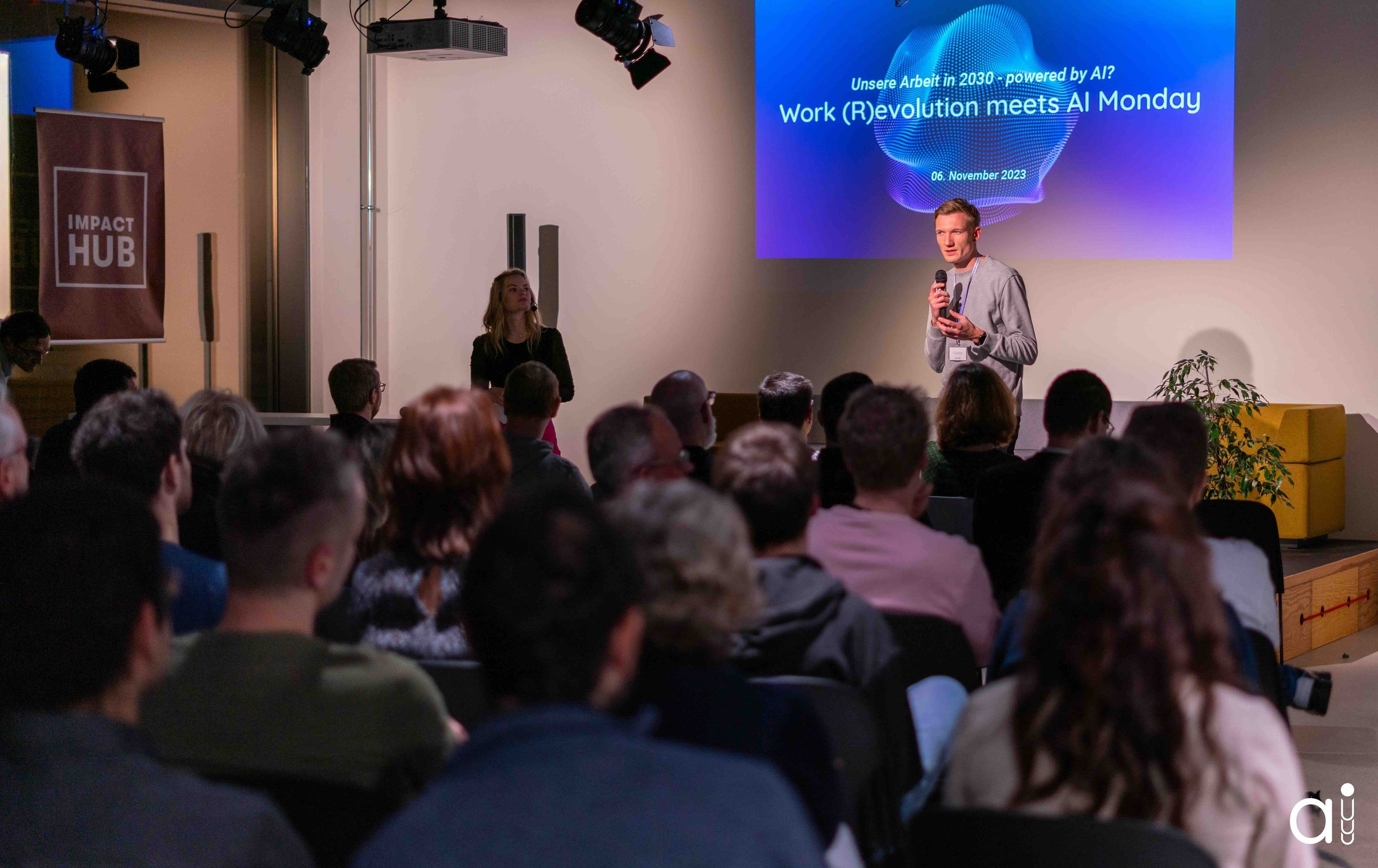 Ein Mann hält bei einer Veranstaltung mit dem Titel 'Work (R)evolution meets AI Monday' am 6. November 2023 einen Vortrag vor Publikum.