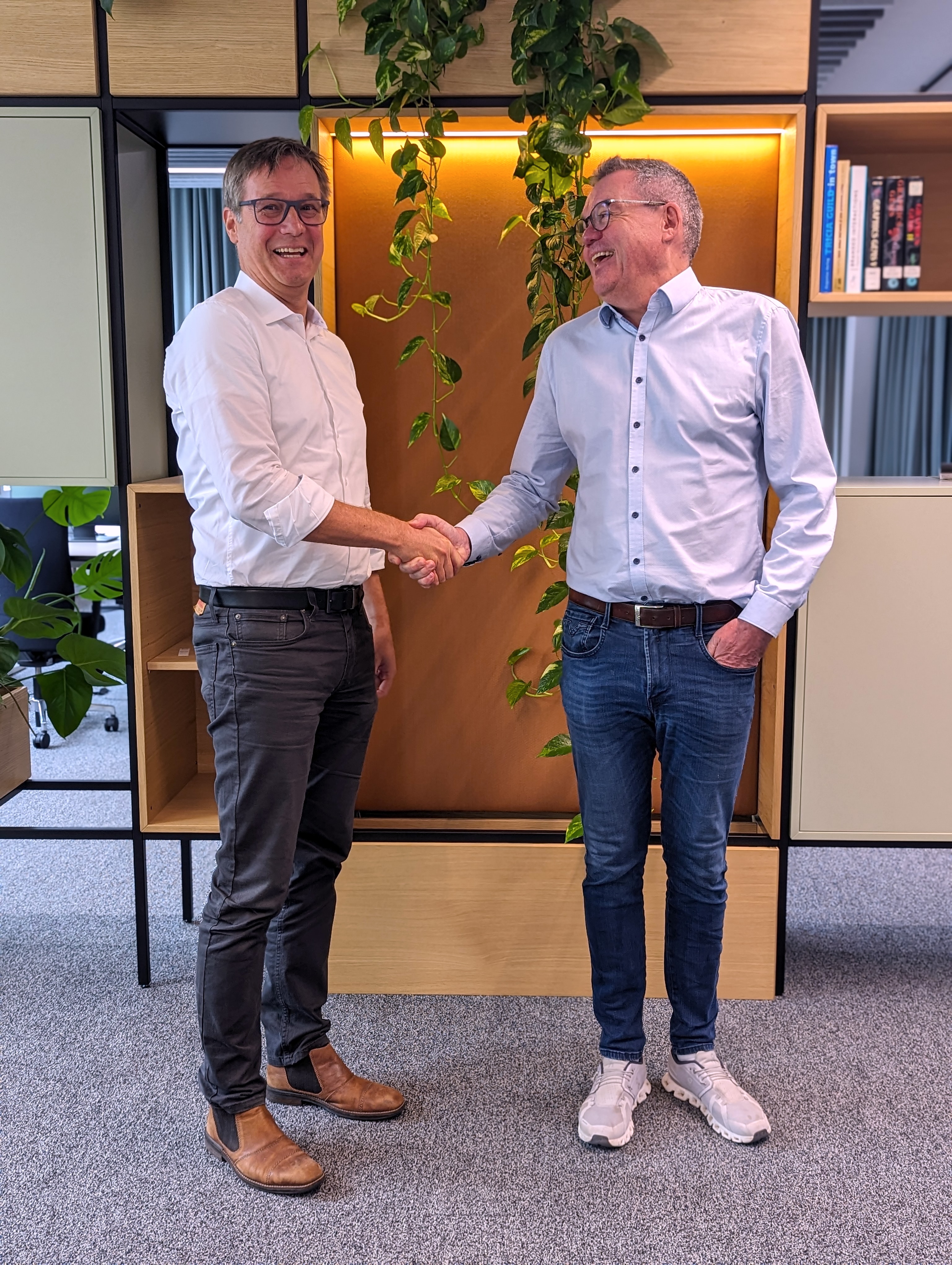 Dr. Detlef Schneider, CEO ALLPLAN (links) und Dr. Günther Möckesch, CEO elevait (rechts) besiegeln die Partnerschaft mit Handschlag nach der Unterzeichnung.