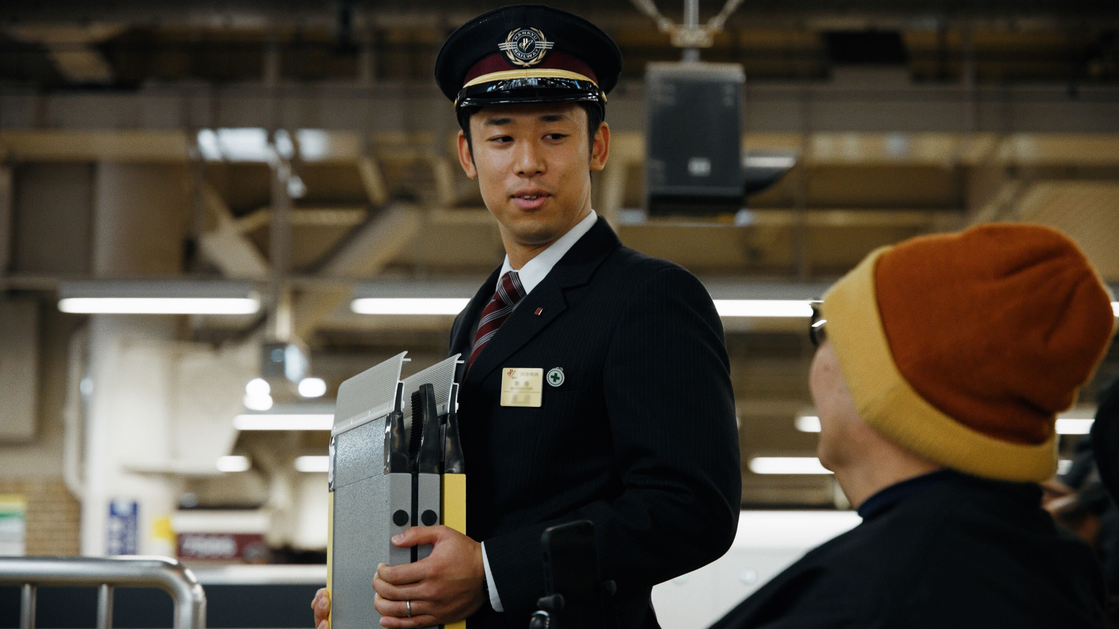 Image of Hankyu Station Staff helping man on wheelchair