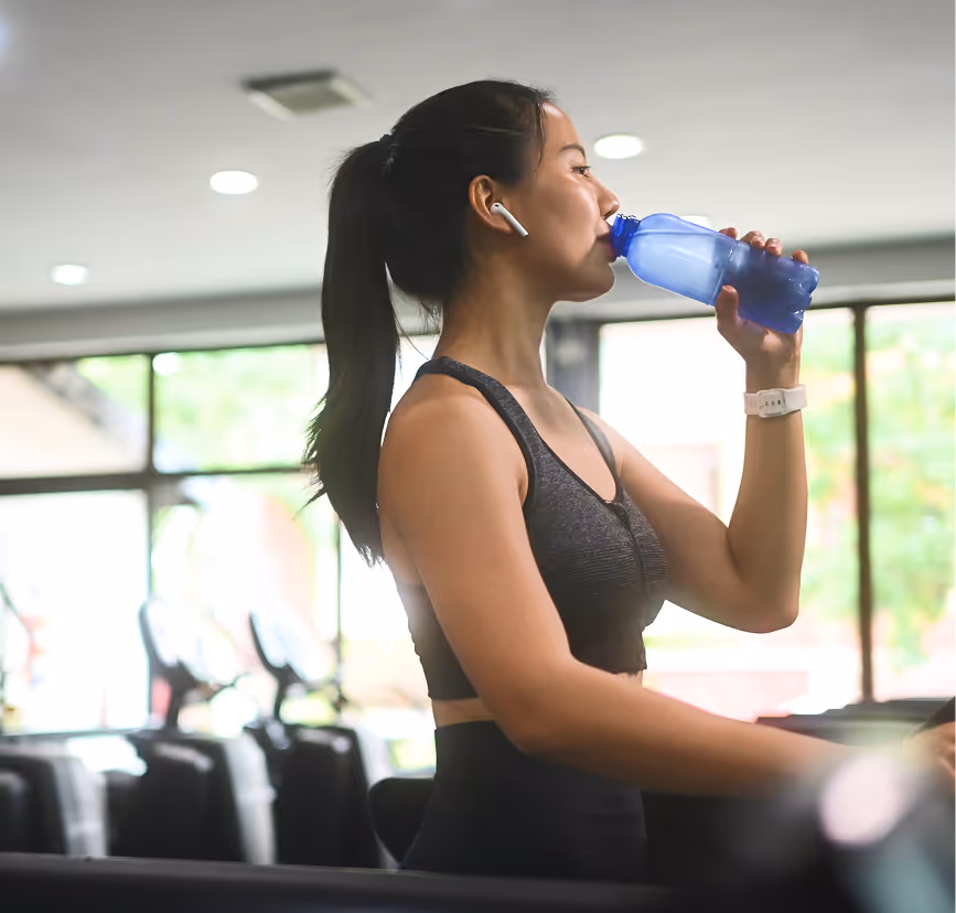 Woman training on cardio machine in a bright, modern 24/7 gym