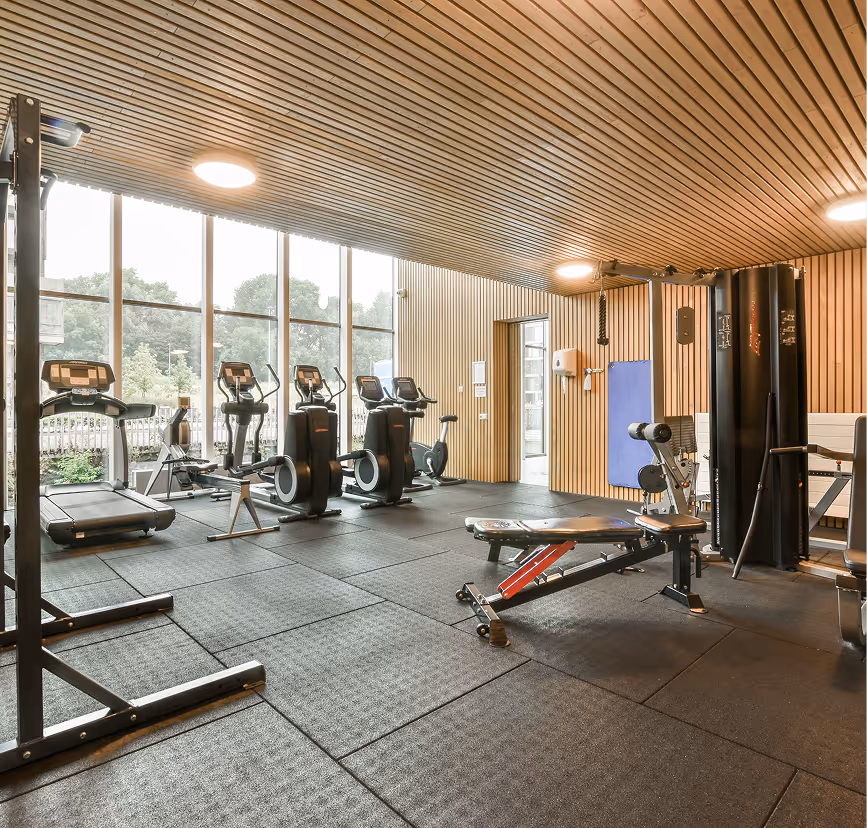 Woman training on cardio machine in a bright, modern 24/7 gym