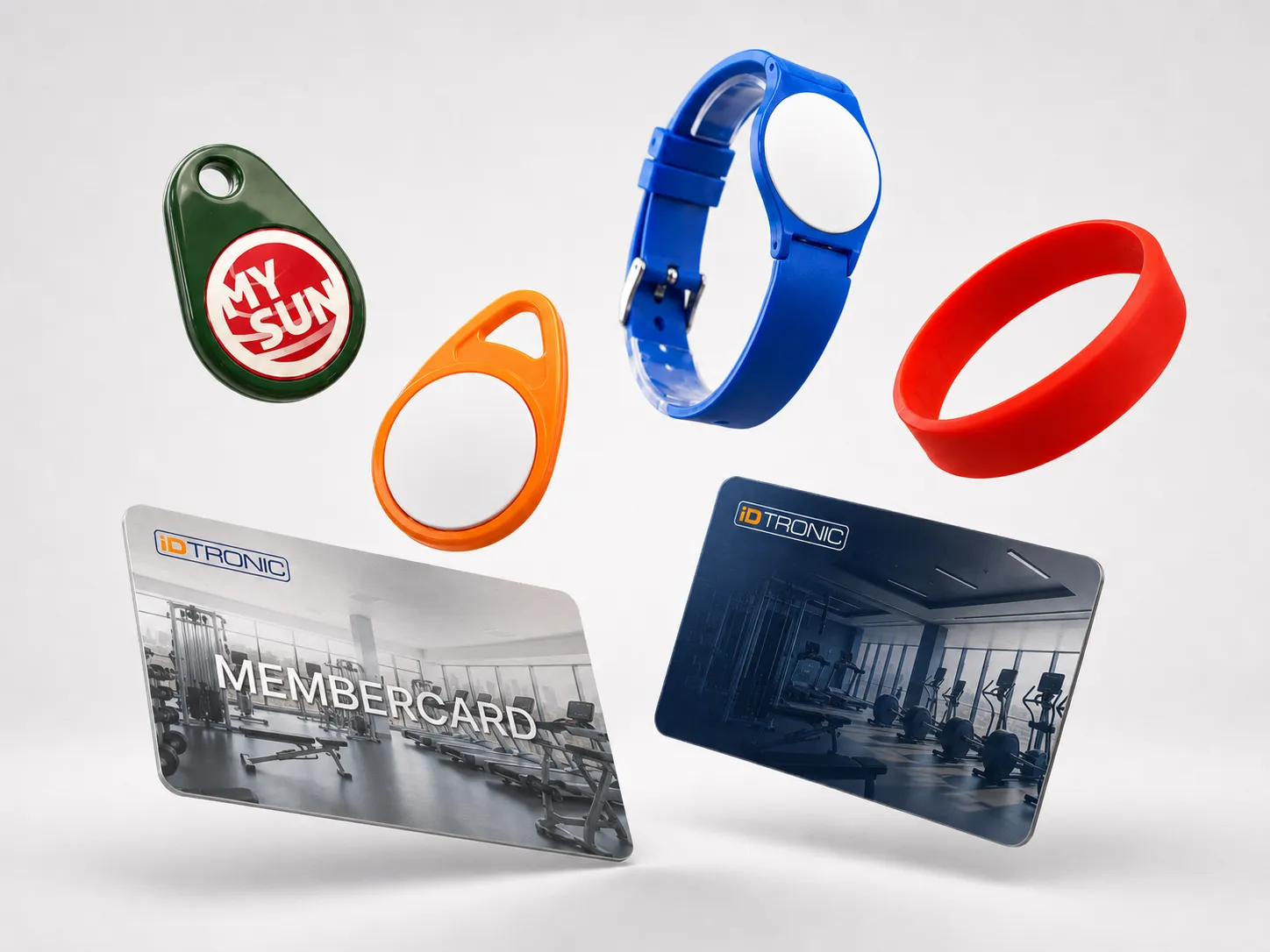 Verschiedene RFID-Armbänder, Anhänger und Mitgliedskarten vor grauem Hintergrund.