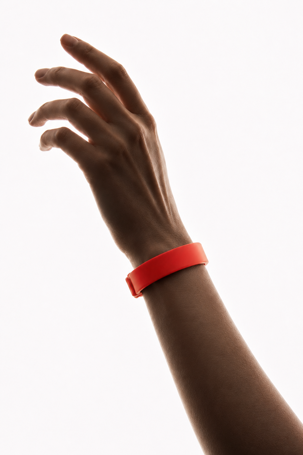 Hand mit erhobenem Finger, das ein rotes Armband am Handgelenk trägt vor hellem Hintergrund.