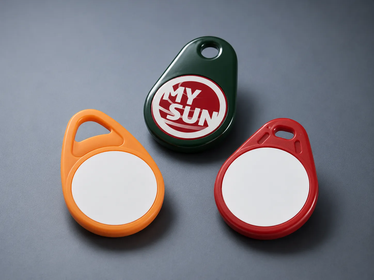 Drei bunte Schlüsselanhänger, einer grün mit 'MY SUN'-Aufdruck, zwei ohne Beschriftung.