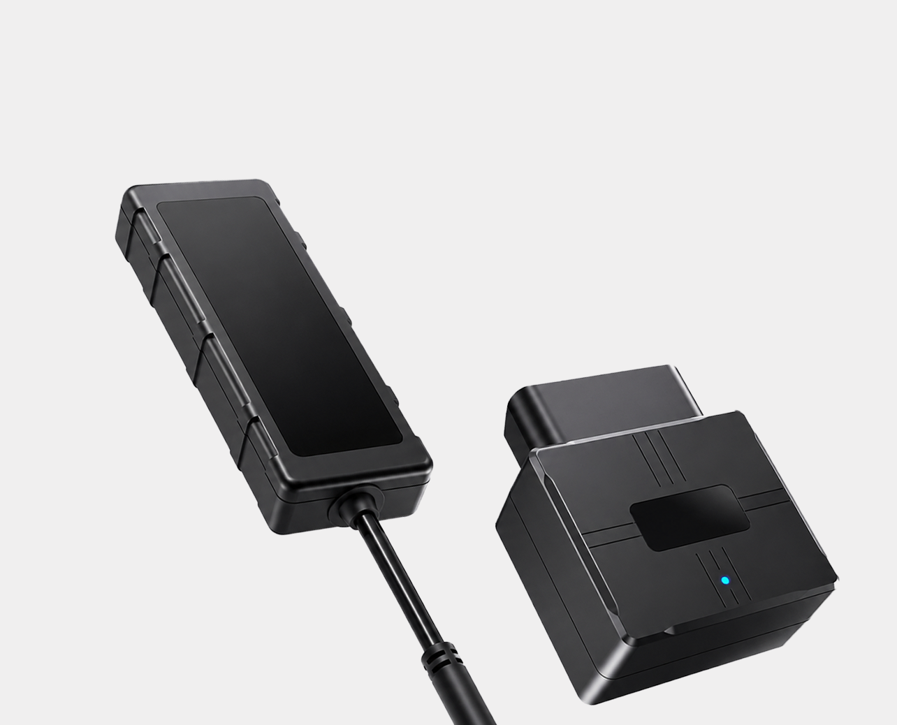 Schwarze Fahrzeugortungsgeräte mit Kabel und Stecker auf grauem Hintergrund.